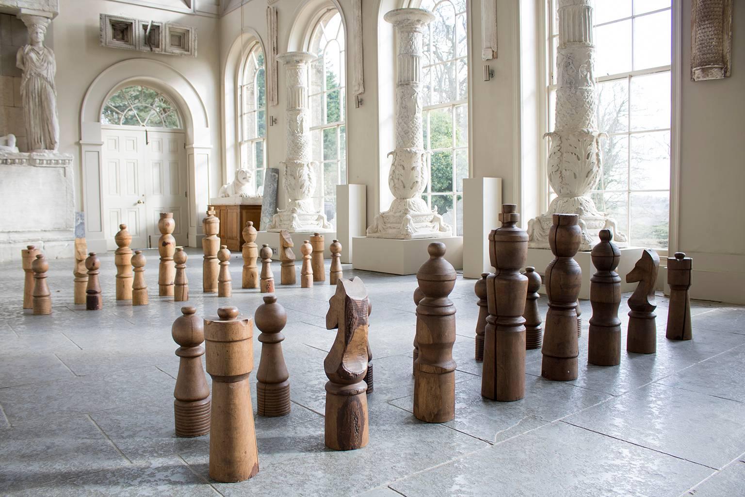 A late 20th Century monumental decorative garden chess set, the thirty-two architecturally styled and turned oak and ash pieces of graduated form. 

Please note, dimensions listed are for the King chess piece.

Please enquire about international