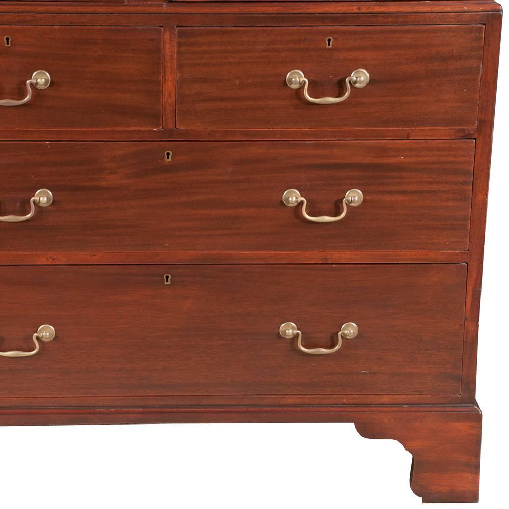 English linen press in solid mahogany, featuring three slide out drawers inside, two small drawers as well as two large drawers below the doors, for ample storage. The linen press has the original antique brass hardware, crown molding and beautiful