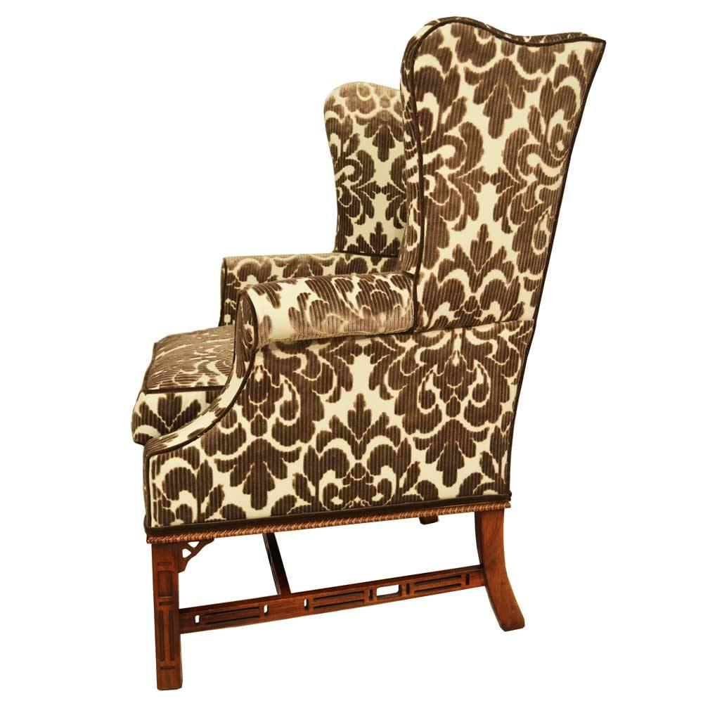 Pair of Classic English Chippendale wing chairs with intricately hand-carved legs and stretchers. Chairs are newly upholstered in an Ikat fabric that is cream and taupe.
Seat height: 23 inches.
 