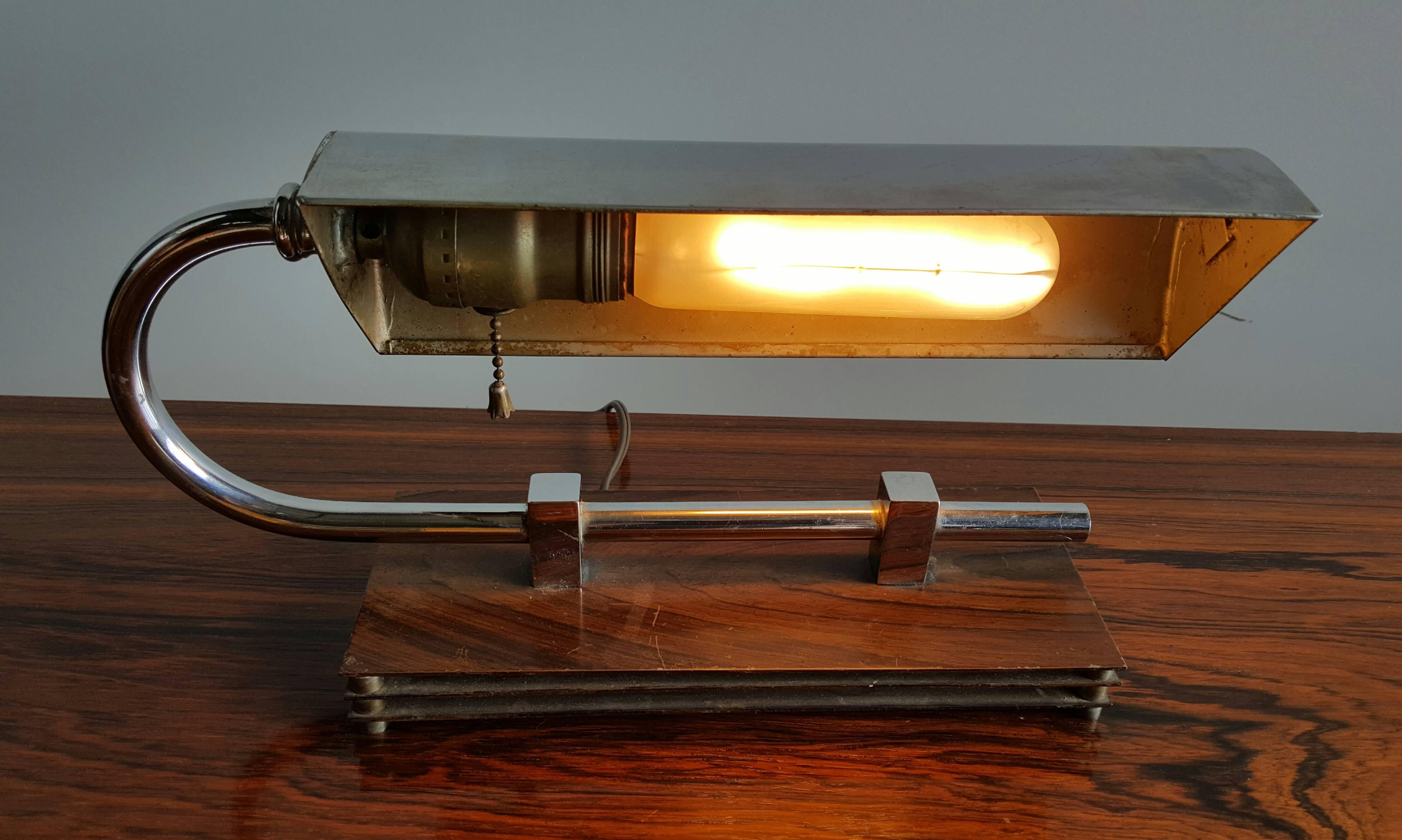 Art Deco machine age chrome desk lamp. Manner of gilbert Rhode. Classic Art Deco, 1930s design. Triple stacked metal base separated by machined steel discs, cantiliver chrome standard with adjustable chrome shade.