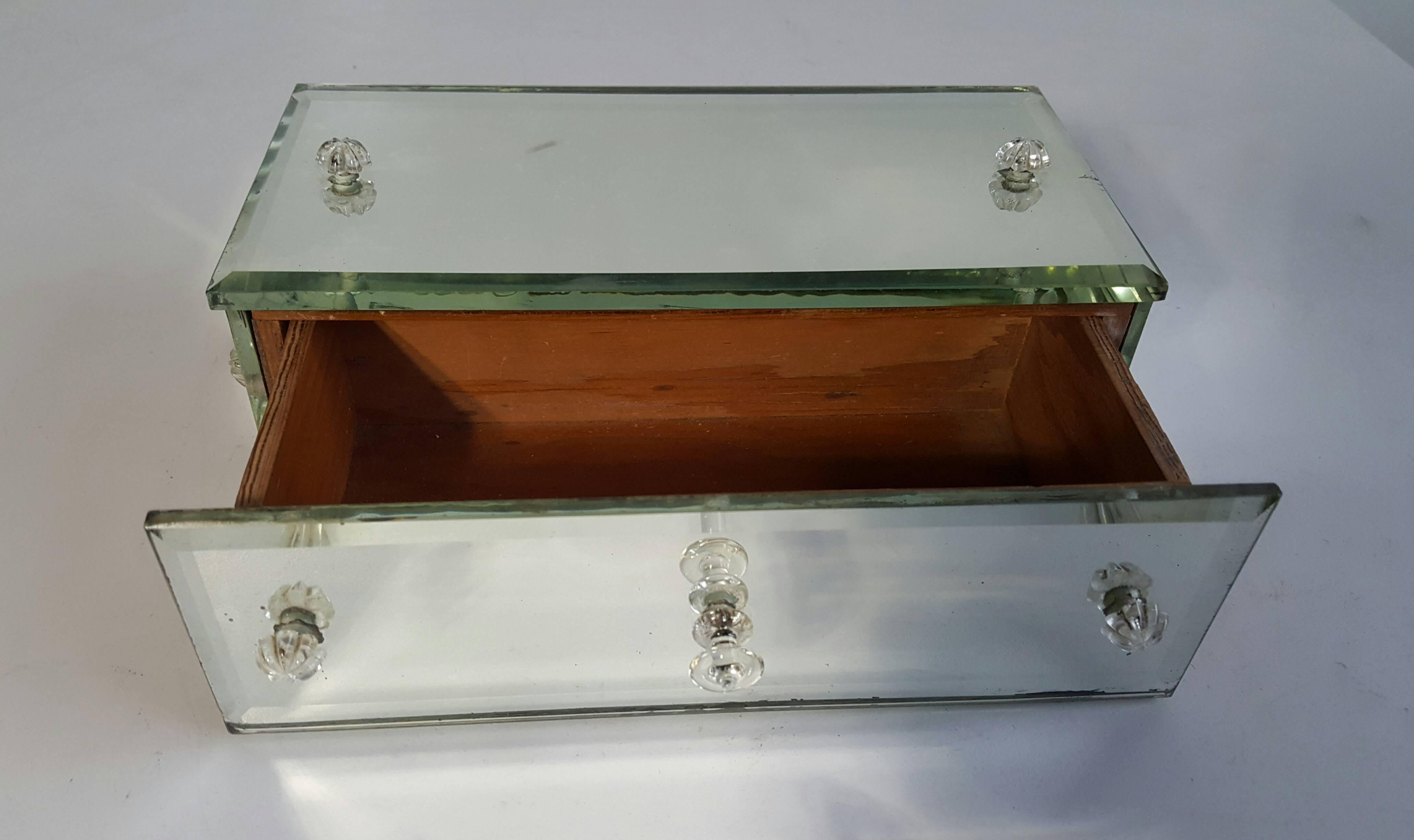 Charming little mirrored trinket / jewelry box, beveled mirror to all five sides as well as cut-glass pull and accents. Classic 1940s dresser accessory.