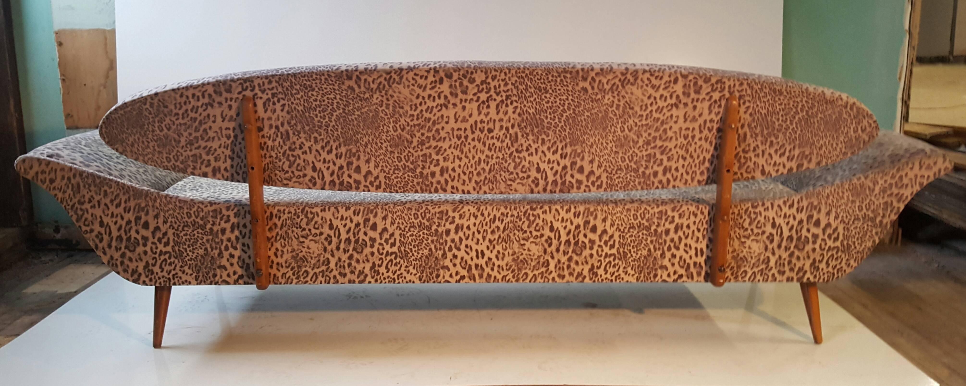 Sculptural Modernist gondola sofa, unusual surfboard floating back. Stunning design! Sculptural. exaggerated walnut frame. Classic modernist conical legs. Looks amazing from all angles. Recently reupholstered expensive leopard print..