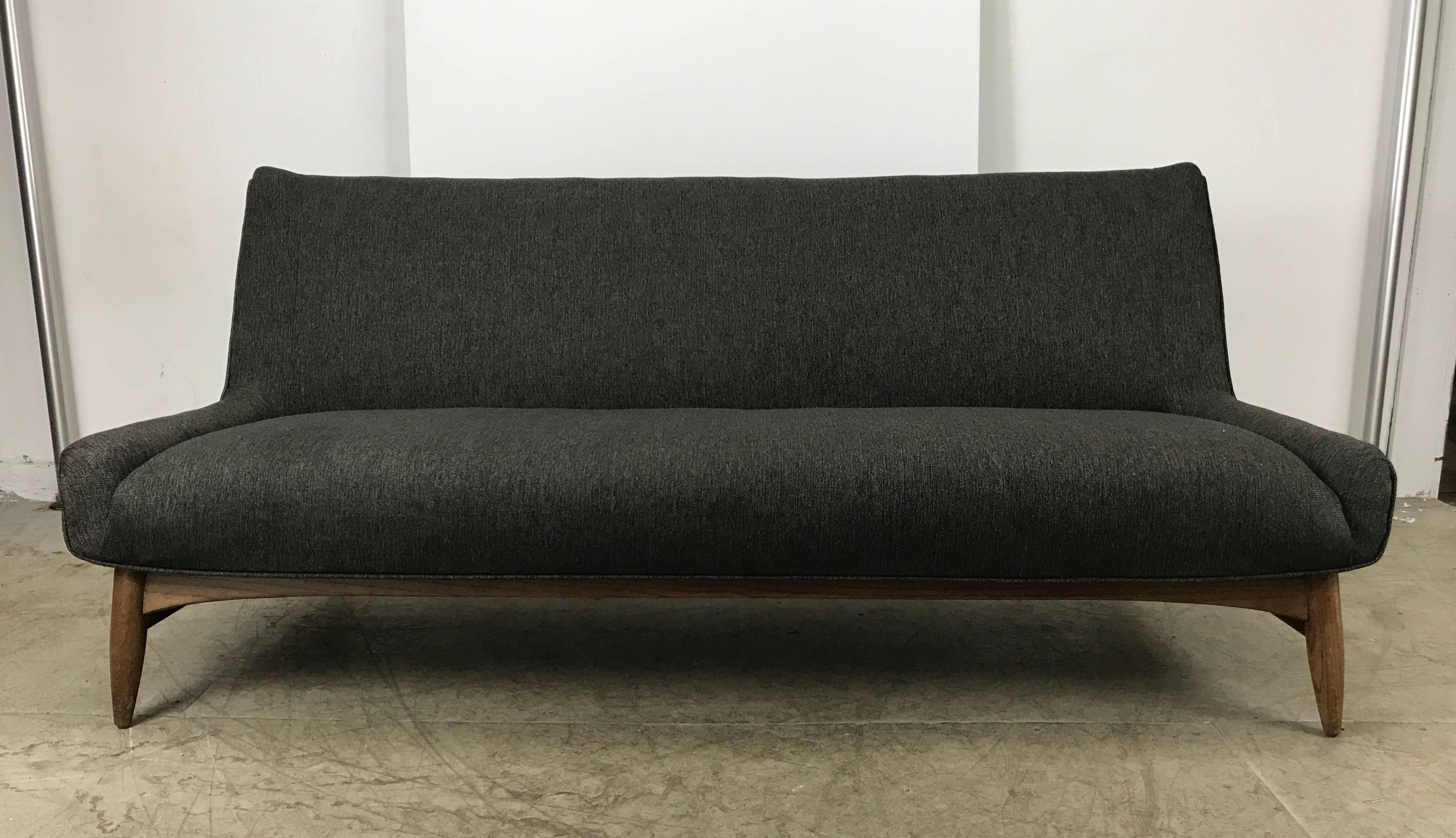 Stunning Danish modern sofa manner of Finn Juhl, Classic styling. Extremely comfortable, Recently reupholstered in a high quality grey wool fabric. Sculptural walnut wood frame. Hand delivery avail to New York City or anywhere enroute from Buffalo