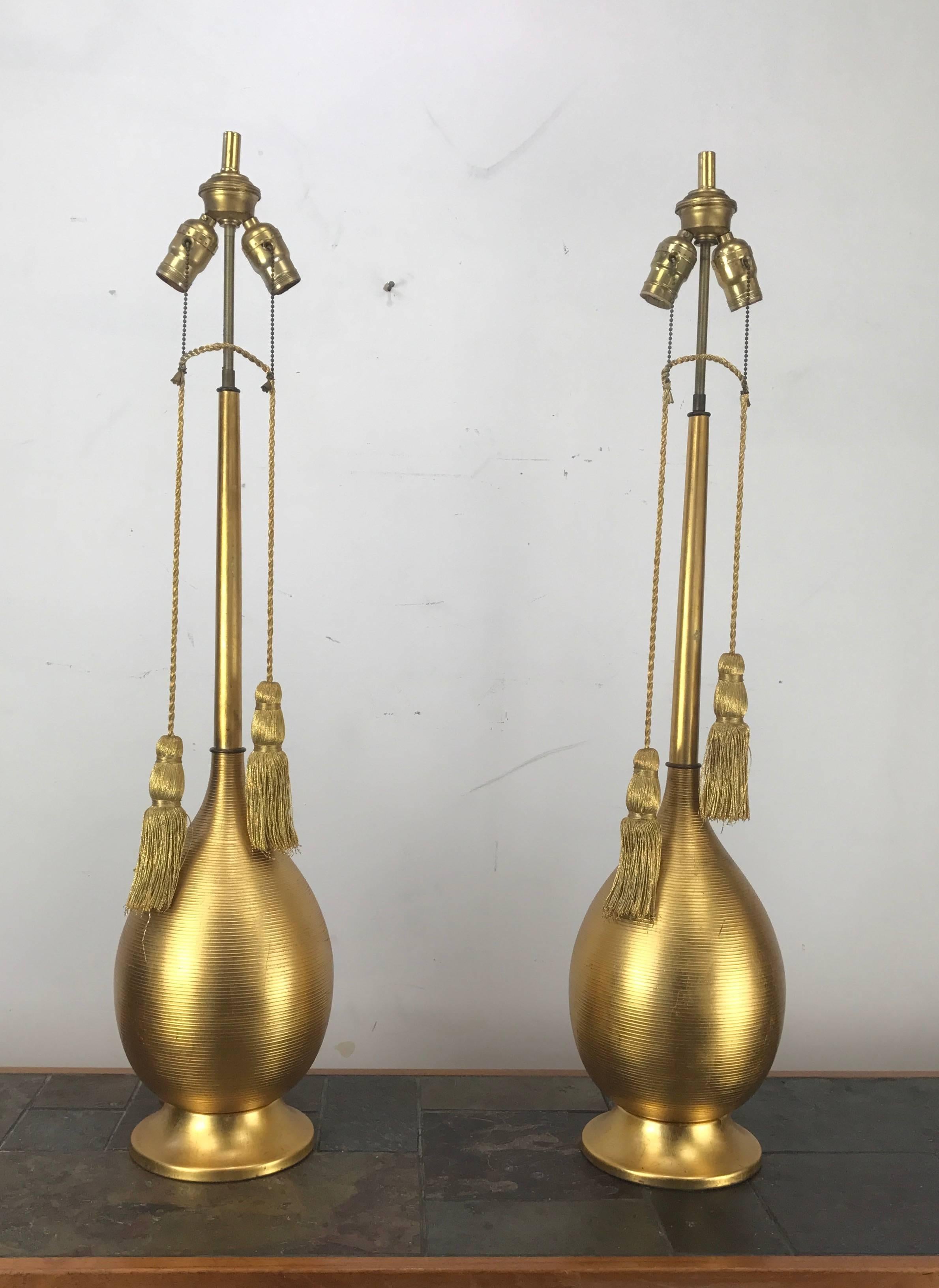Classic Mid-Century Modern gilded ribbed metal table lamps, original rope tassel pull chain on/off switch, Wonderful bulbous form, graceful tapered standard, Great style, patina and proportion.