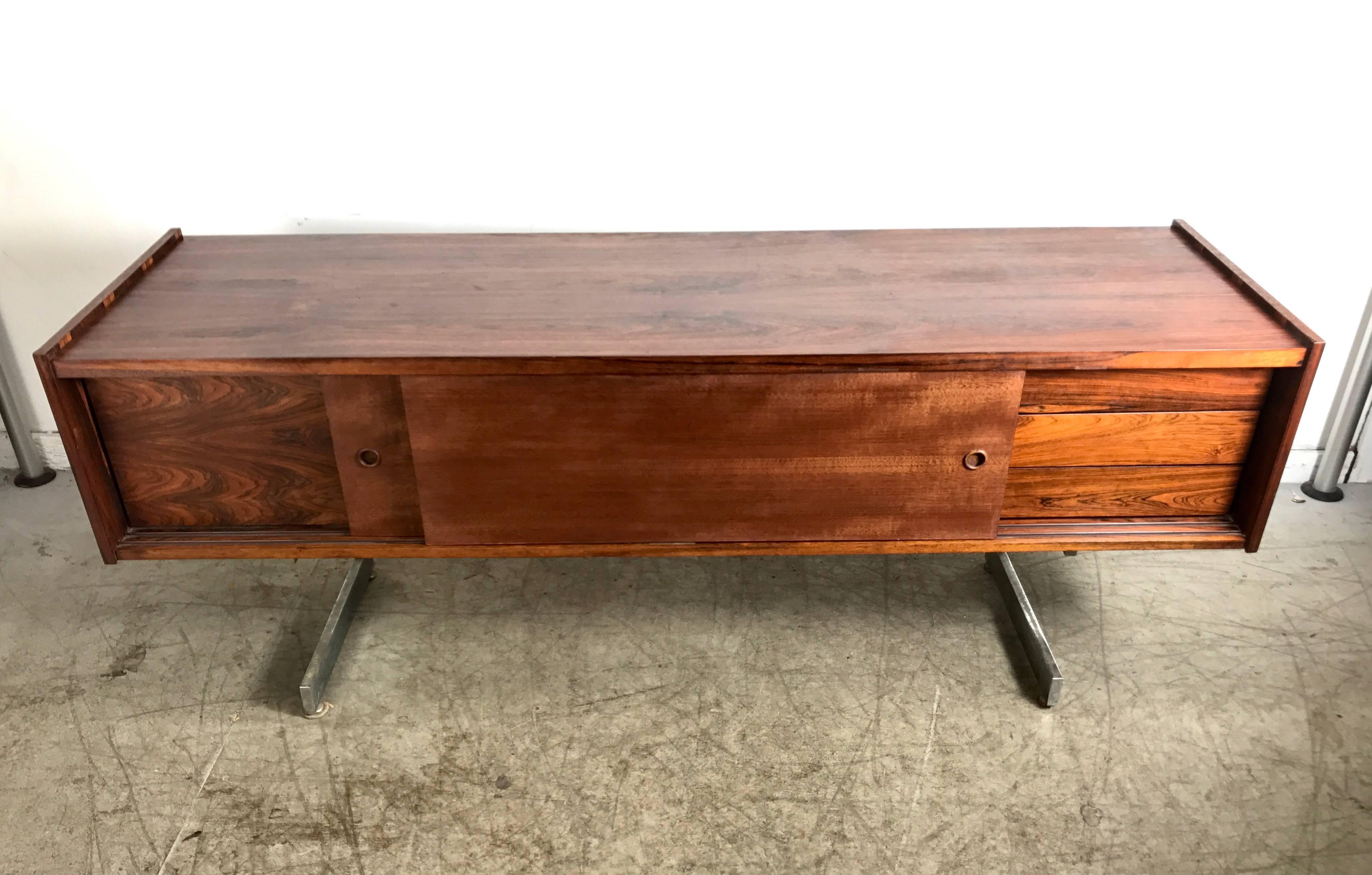 Mid-Century Modern cantilevered rosewood credenza, stunning design, superior quality and construction. Features two sliding doors, drawers to right side, file drawer to left..Hand delivery avail to New York city or anywhere en route from Buffalo NY.