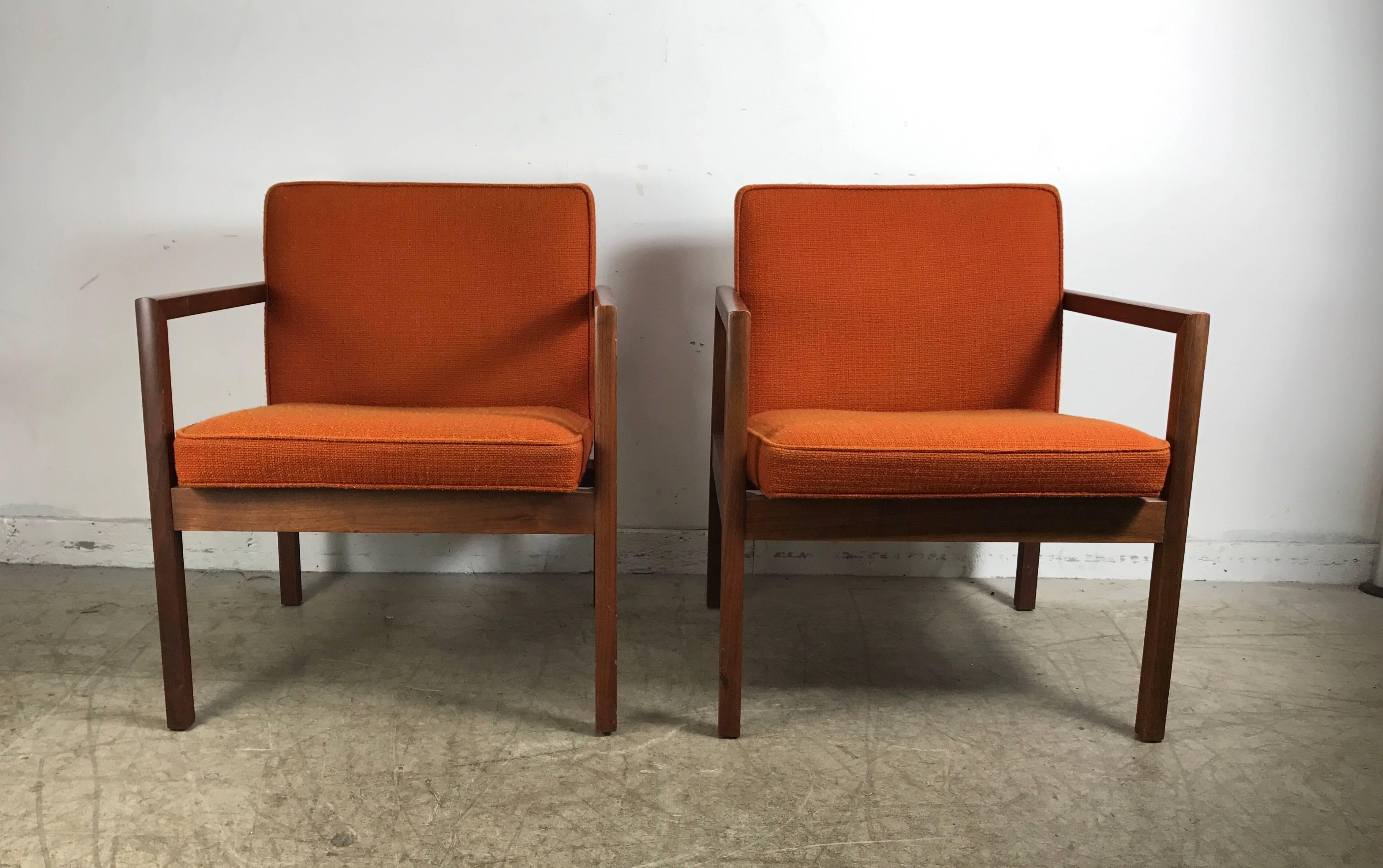 Pair midcentury solid walnut lounge chairs by Stow Davis, handsome architectural profile in the style of Jens Risom. Superior quality and construction, retains original orange wool fabric, extremely comfortable, total of four chairs available.