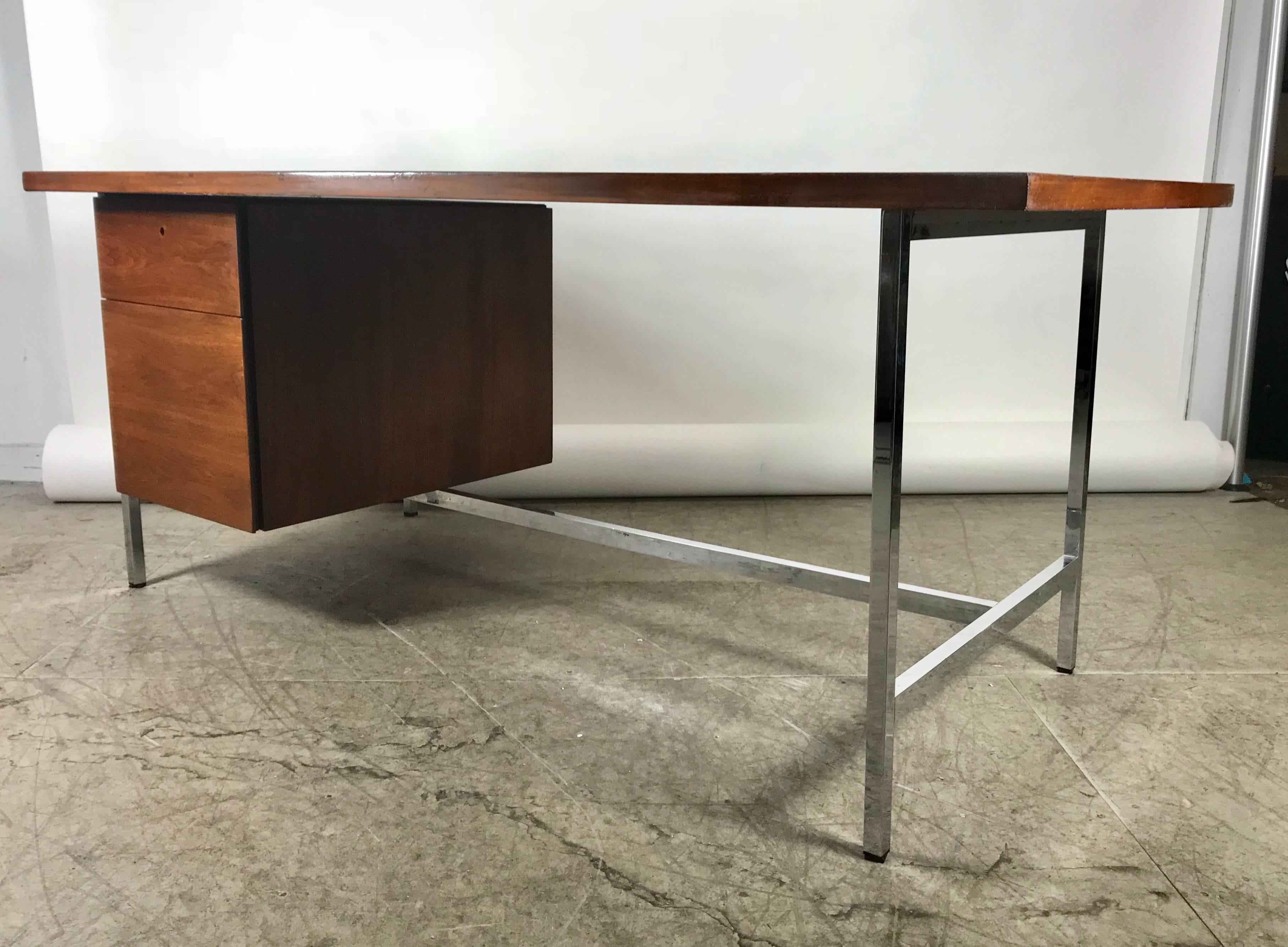 Classic midcentury walnut and chrome Florence Knoll desk features richly grained walnut top chromed steel frame, pencil drawer and file drawer. Retains early Knoll label.