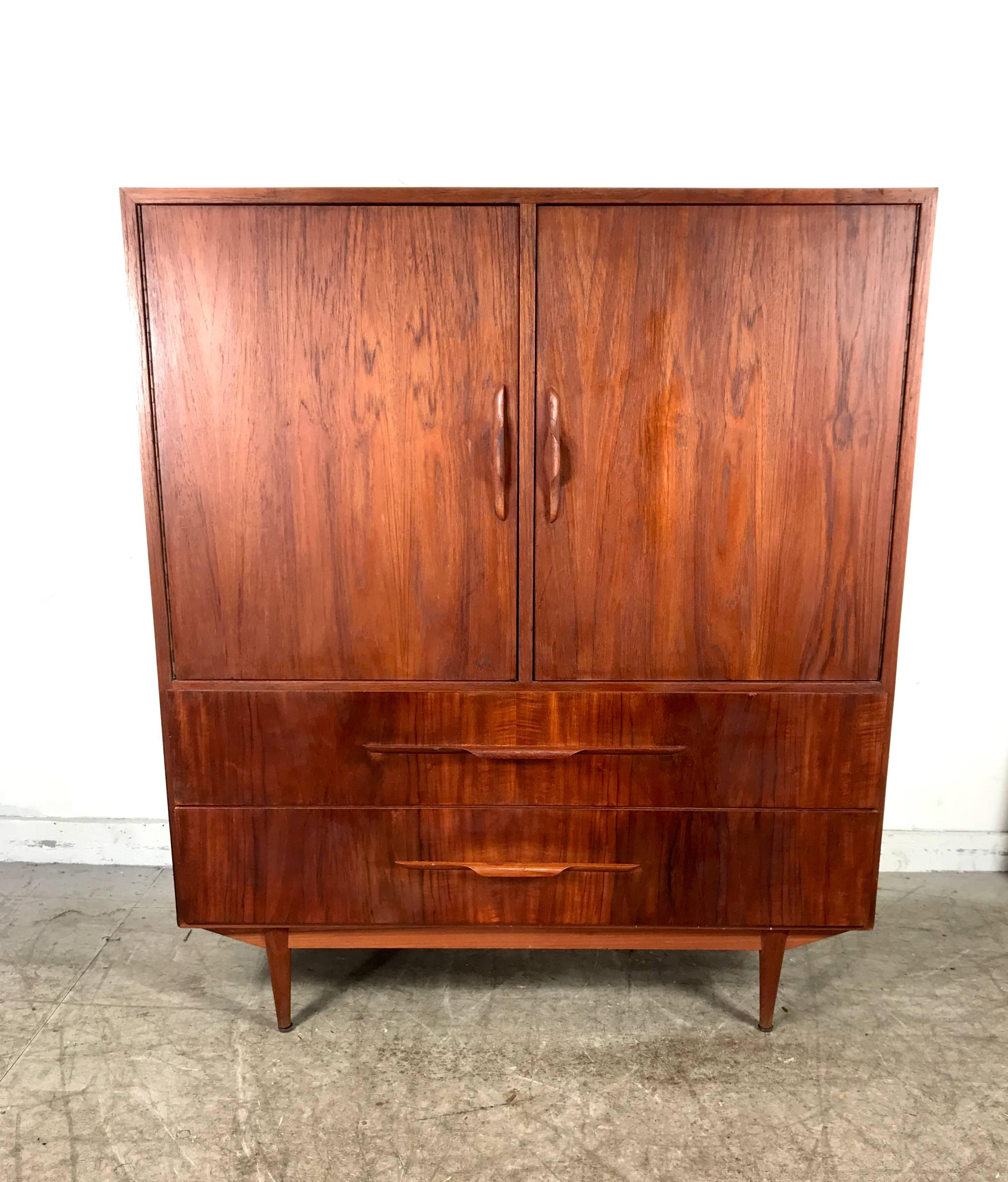 Danish modern teak two-door cabinet manner of Arne Vodder wonderful scale and proportion featuring two large doors and two generous size drawers, superior Danish quality, sculptural door and drawer pulls, Hand delivery avail to New York City or