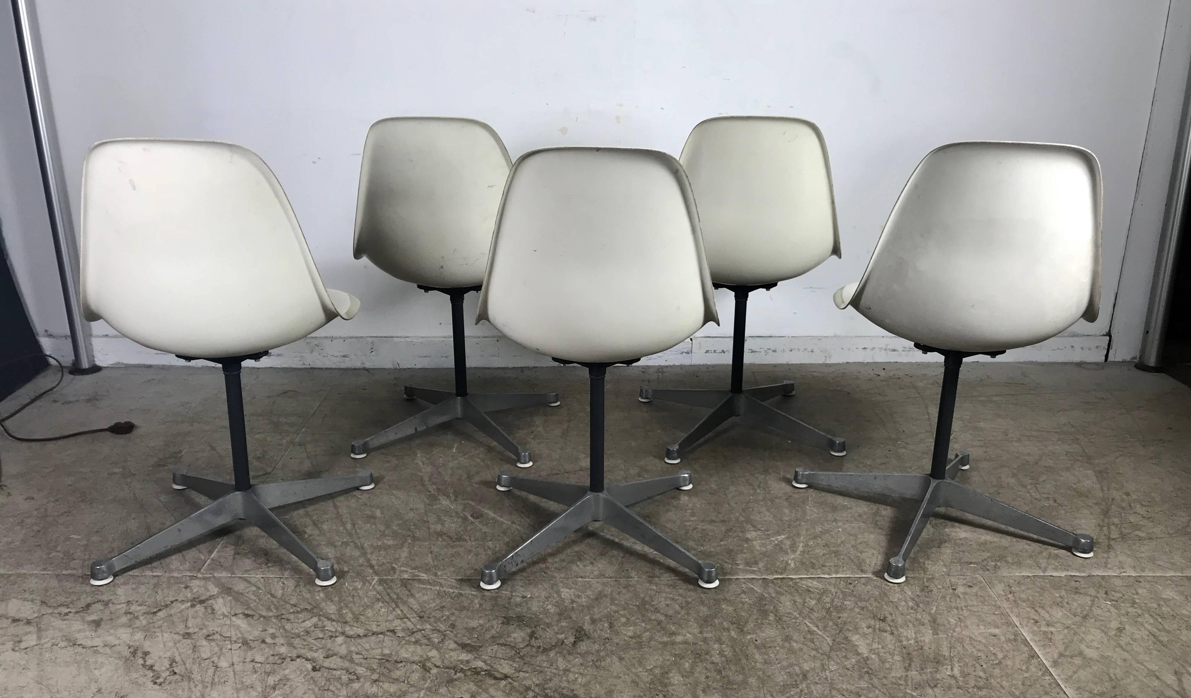 Six Classic Mid-Century Modern fiberglass swivel side shell chairs designed by Charles and Ray Eames, manufactured by Herman Miller. Remarkable condition for there age, early example, beautiful white fiberglass side shells atop cast aluminum four