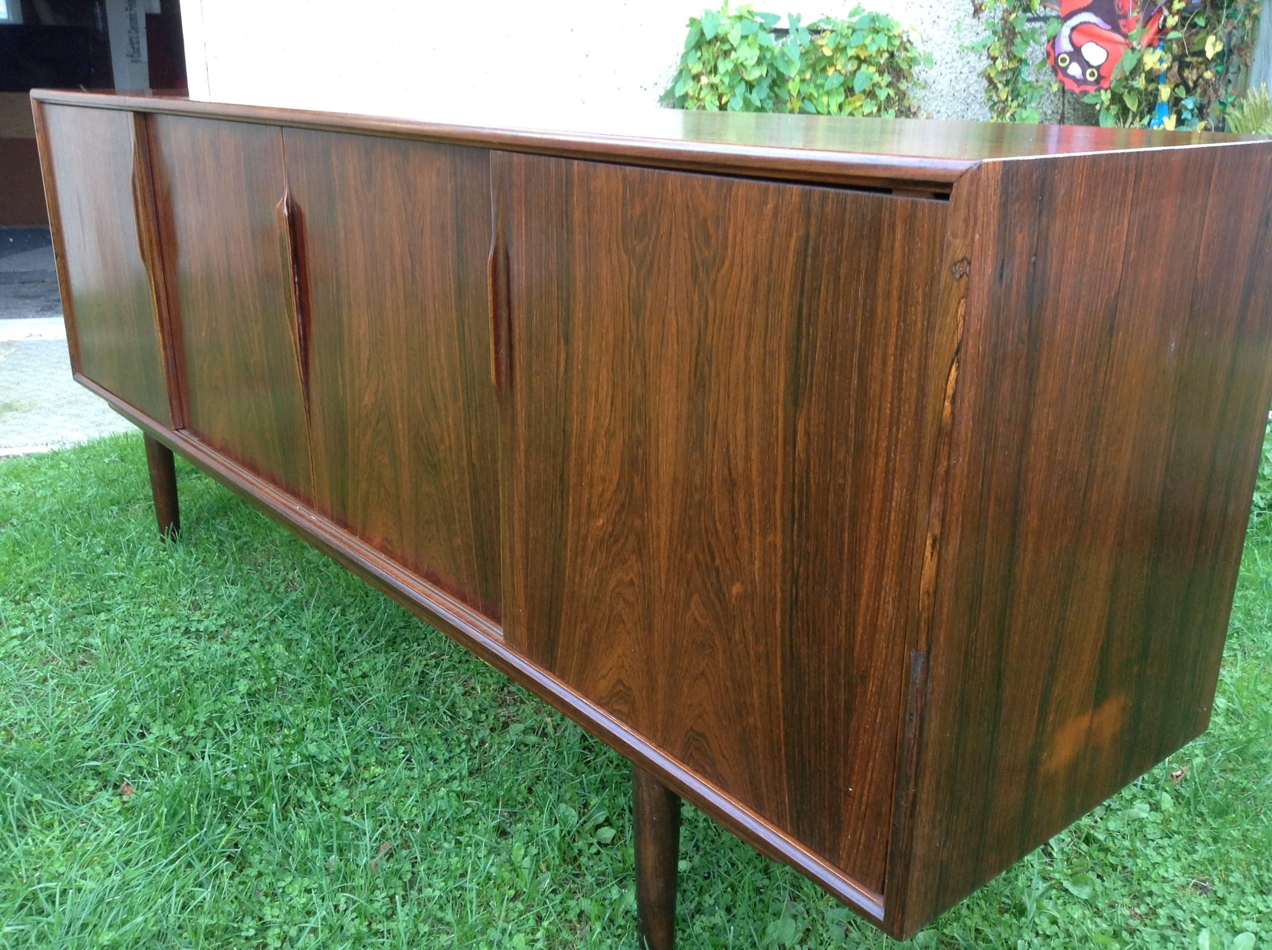 Credenza or Sideboard designed by Gunni Omann and produced by Axel Christensen, Denmark,,beautiful book matched figured rosewood . Four sliding doors ( left) adjustable shelf.,3 drawers.(right) adjustable shelves,