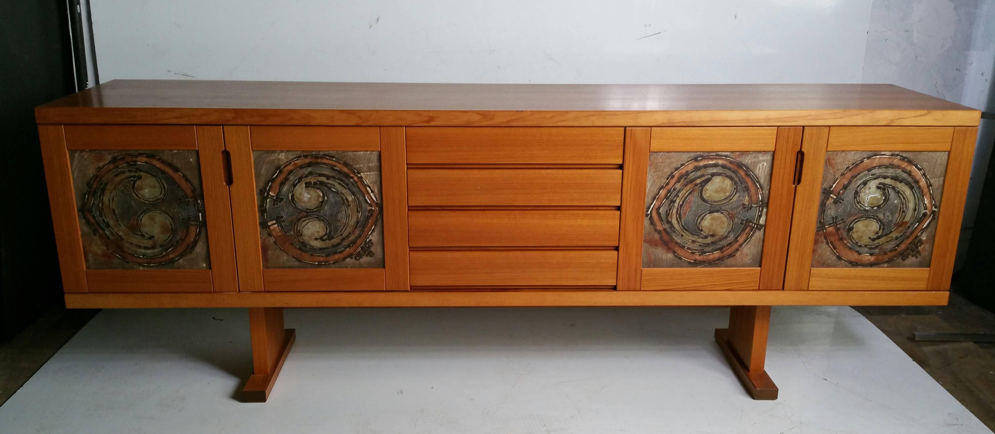 Danish crafts movement sideboard or credenza, manufactured by Gangso Mobler, wonderful large Ox Art tiles to door fronts. Generous storage behind two left and two right doors, four drawers (center), beautifully grained teakwood, finished back.