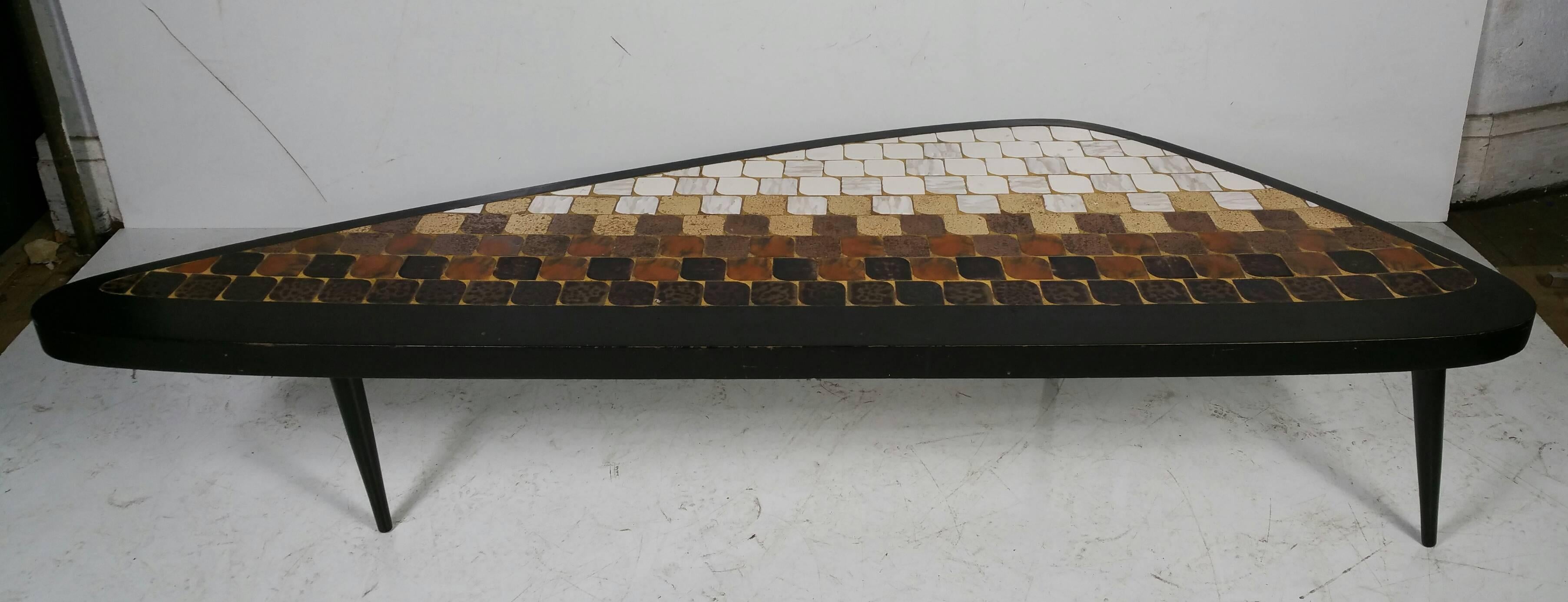 Mid-Century Modern tile top table, manufactured by Hohenberg Originals, unusual guitar pick shape, black lacquer frame, thoughtfully placed earthtone ceramic tiles, wonderful proportion.