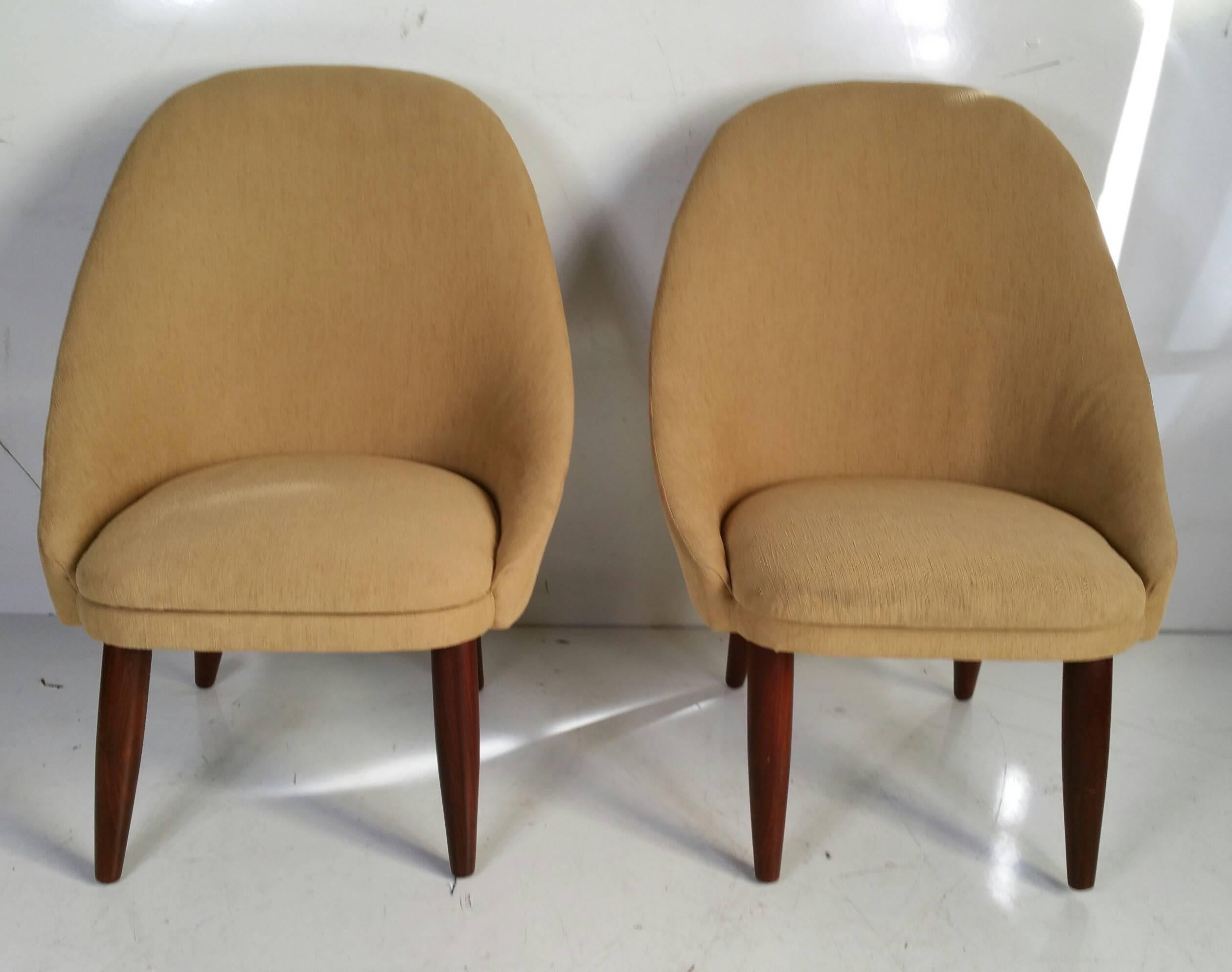Stylized pair of slipper chairs designed by Ejvind Johansson, made in Denmark, recently reupholstered, solid walnut turned legs. Extremely comfortable, great proportions.