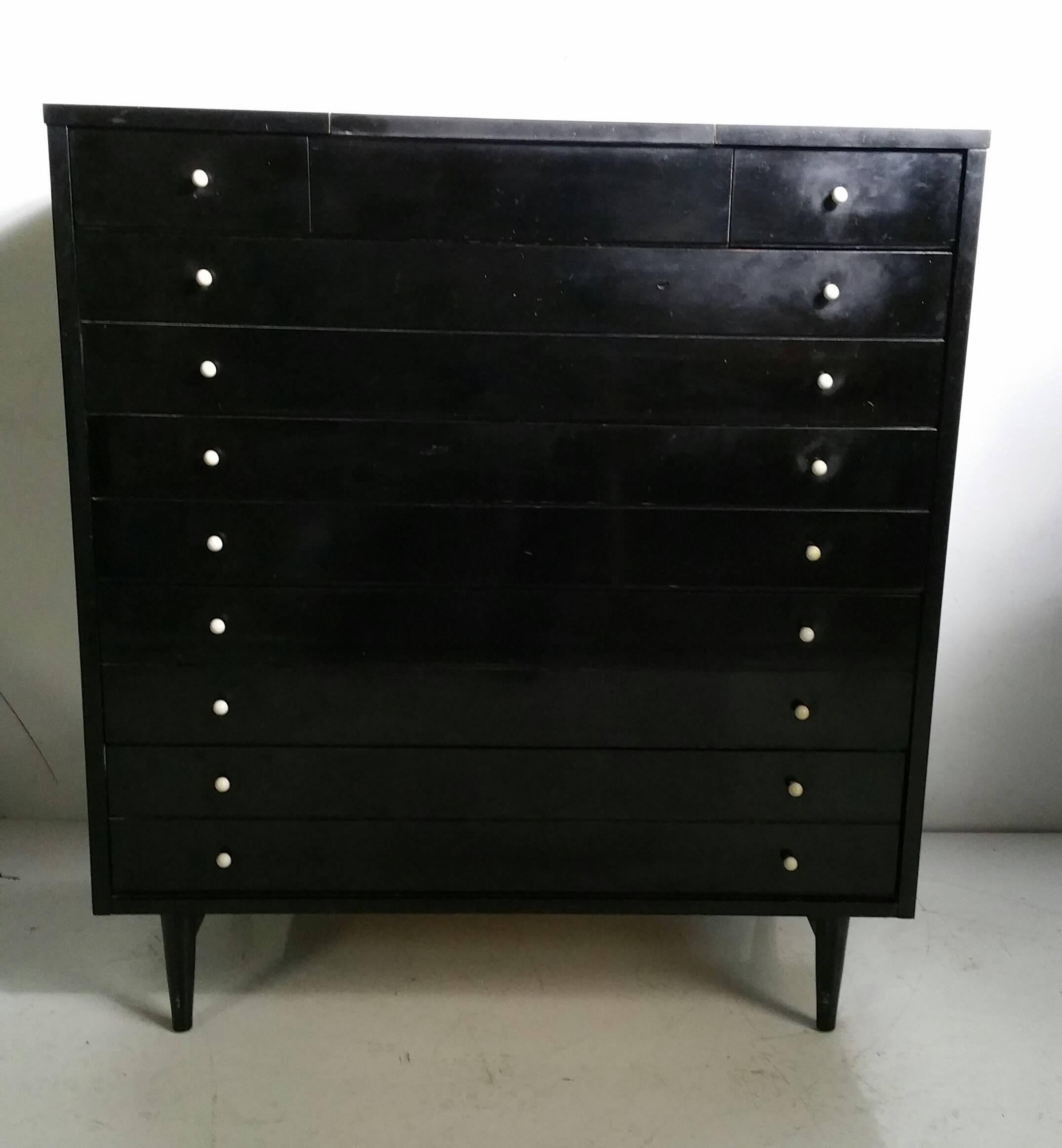 Mid-Century ebonized chest of drawers by American of Martinsville, USA, circa 1950s. Ebonized wood with a white laminate top, unusual pop up mirror, inside jewelry storage, beautiful white glass and brass pulls.. Manner of Paul McCobb.