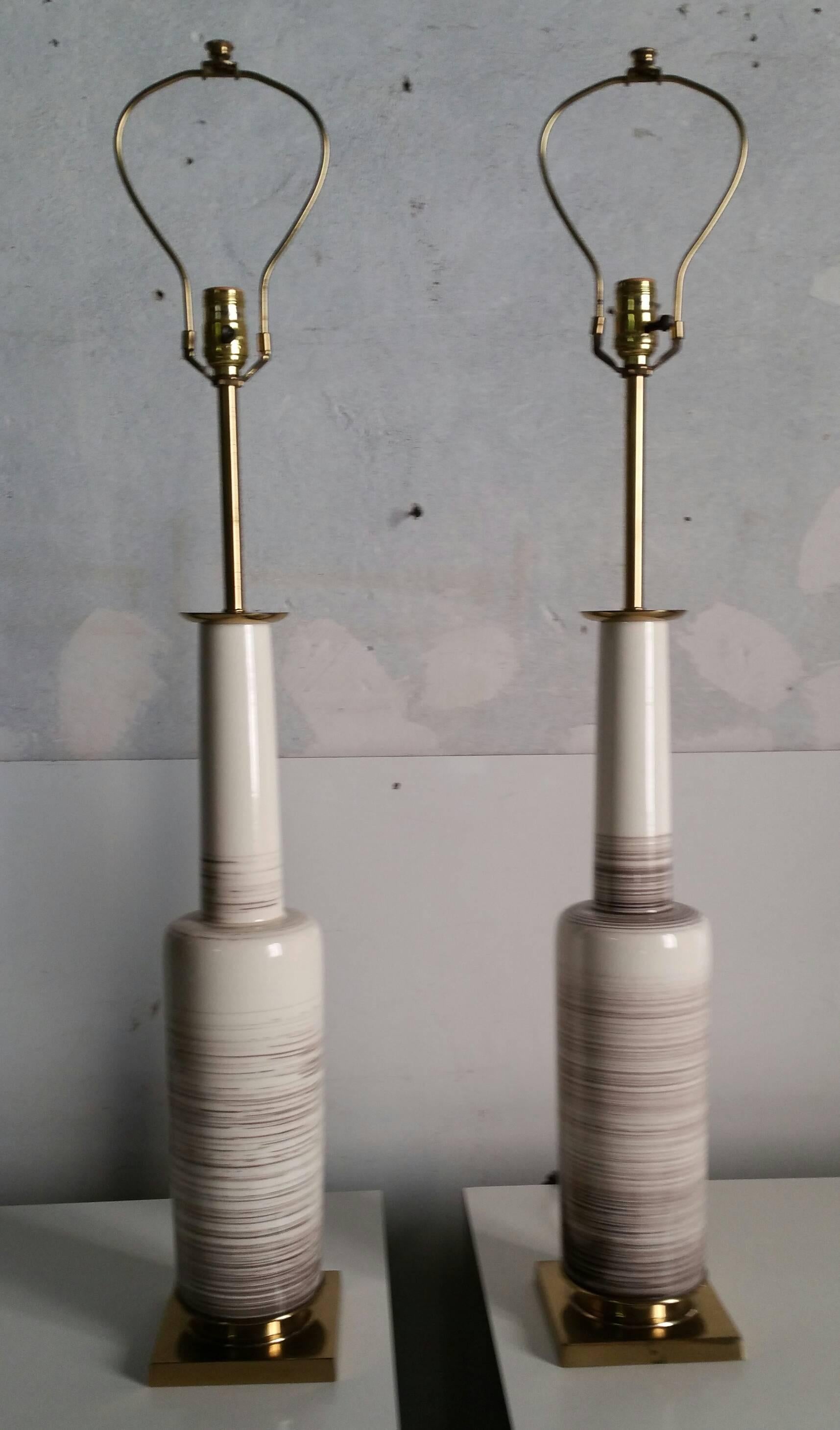 Fantastic pair of stylized modernist ceramic lamps by Stiffel, in an beige gray crackle glaze and satin brass details.Retain original lamp shades in excellant condition,,Shades 15