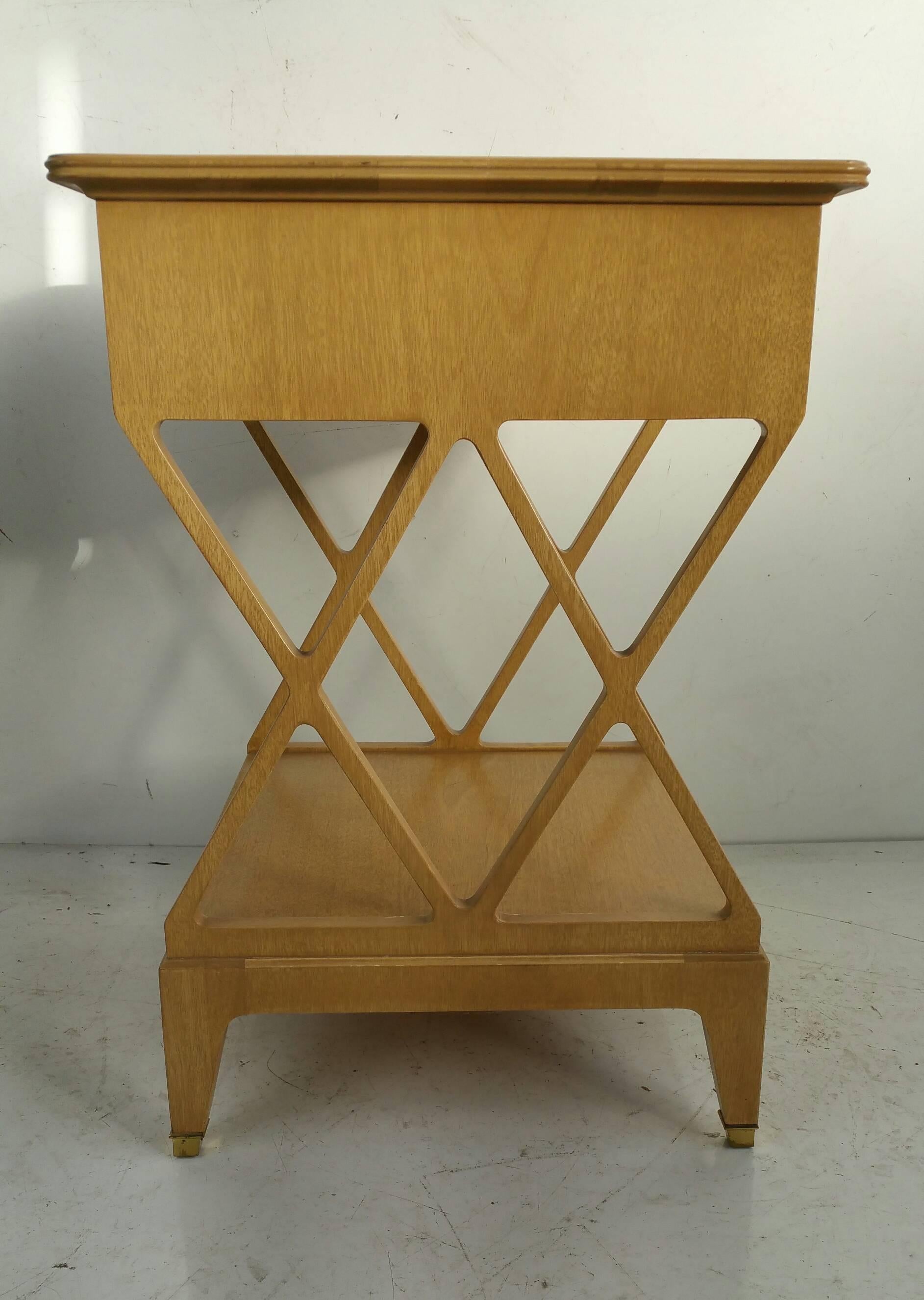 Unusual nightstand/table designed by Renzo Rutili for Johnson furniture warm blonde mahogany, beautiful brass foot detailing, brass and lacquer hand pulls.