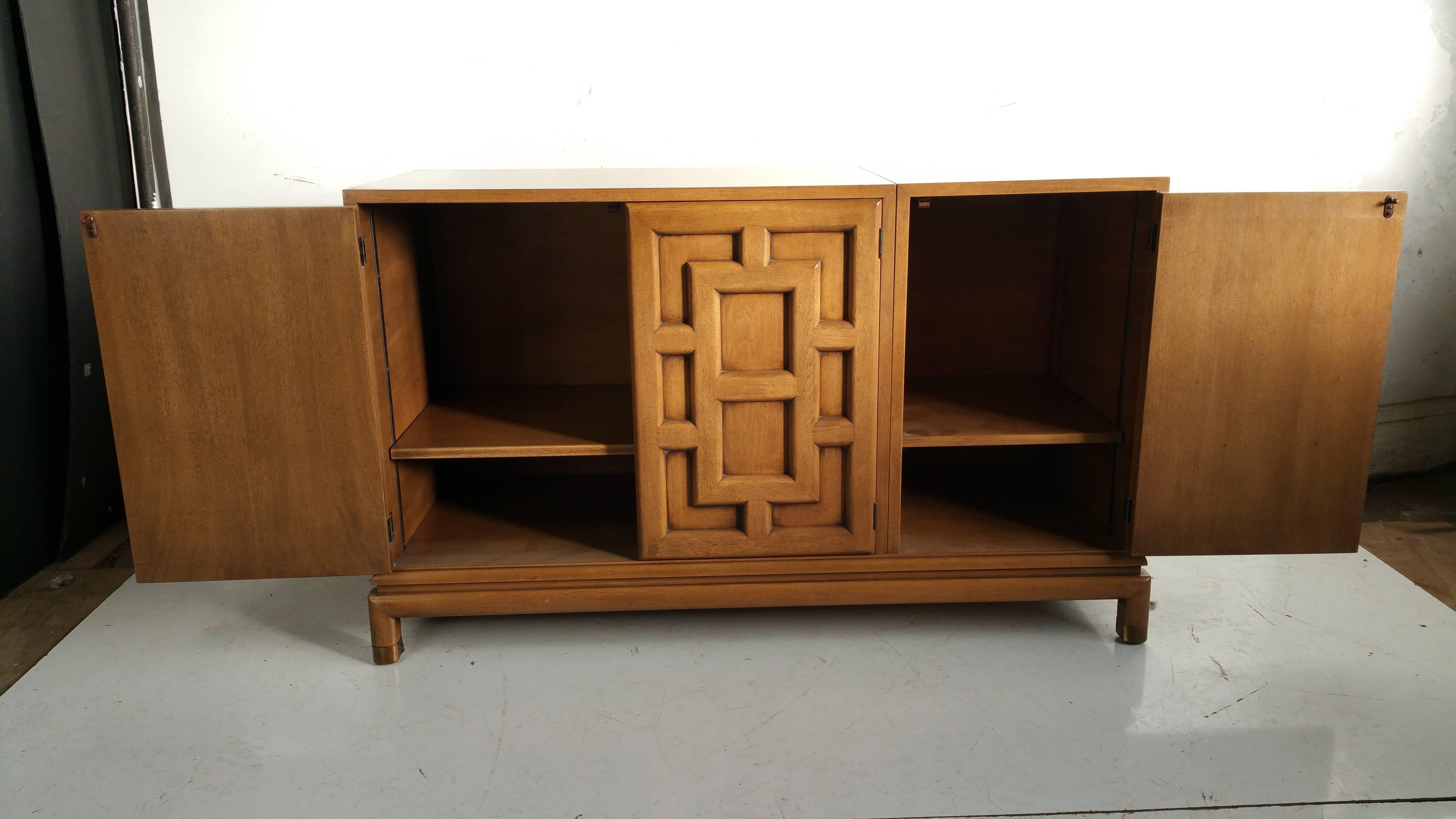 An Asian Modern four-door cabinet designed by Renzo Rutili with fretwork style paneling, 1960s, brass detailed foot. Finished back.