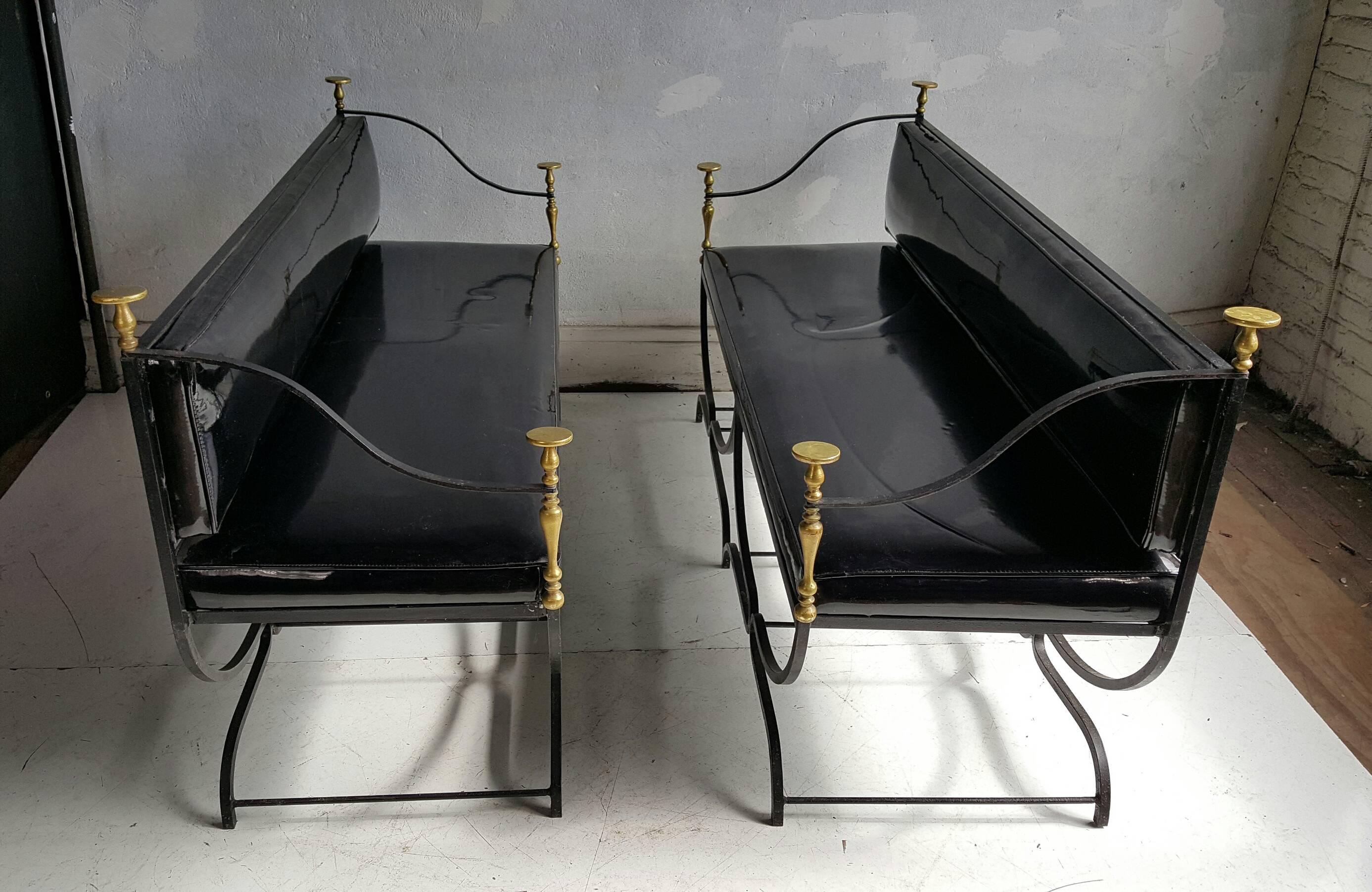 Rare matched pair of Italian Mid-Century iron and brass Savonarola or Curule settees whose form dates to the Renaissance. This particular example features exaggerated brass spheres and finials. The settee's retain their original black patent leather