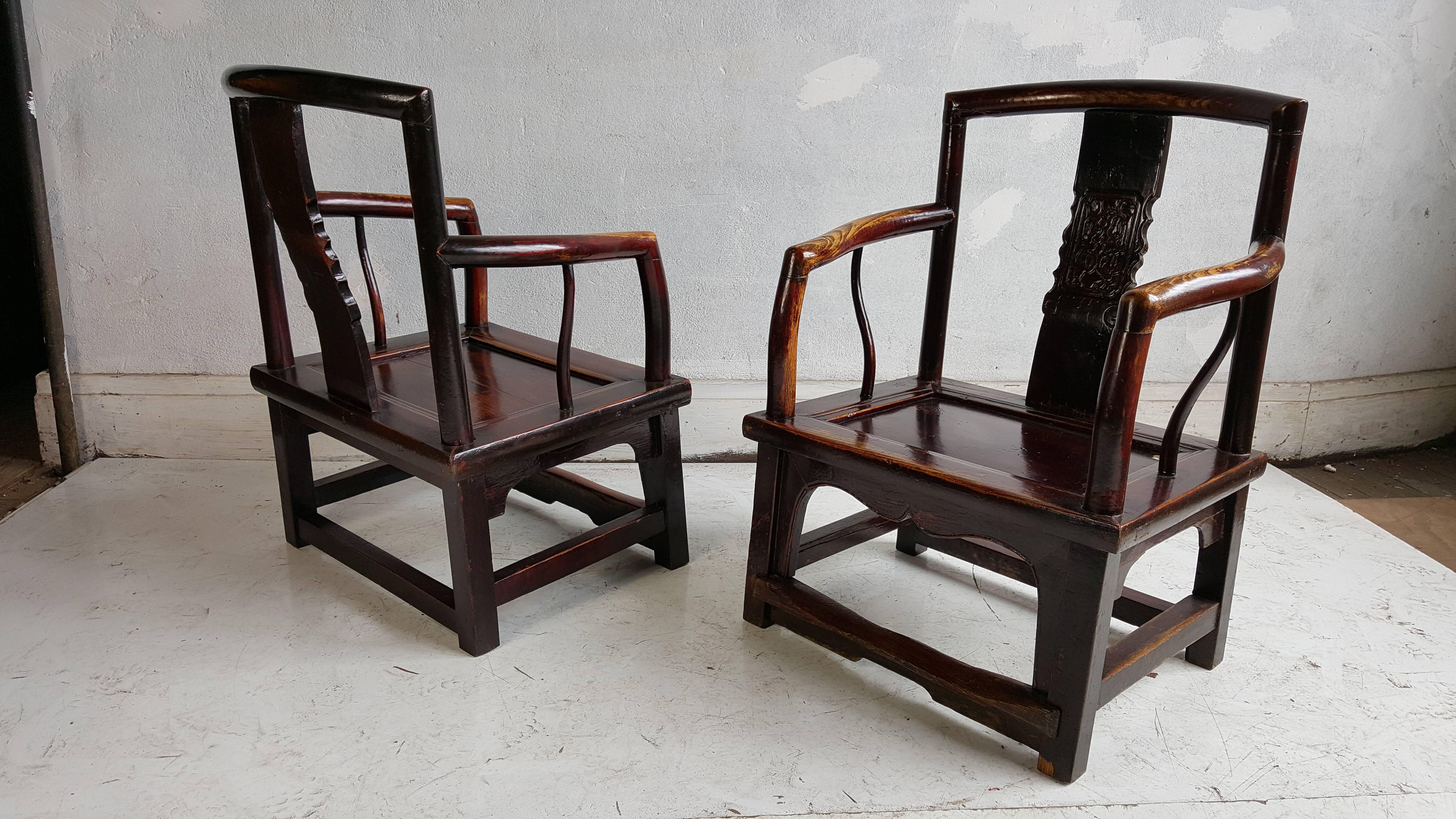 A finely crafted set, four Chinese official's chairs. The center yoke back panel has elegantly carved section. The front leg apron is also beautifully carved. Retains foot rail joining legs. The lacquer finish on the chairs is original. Often this
