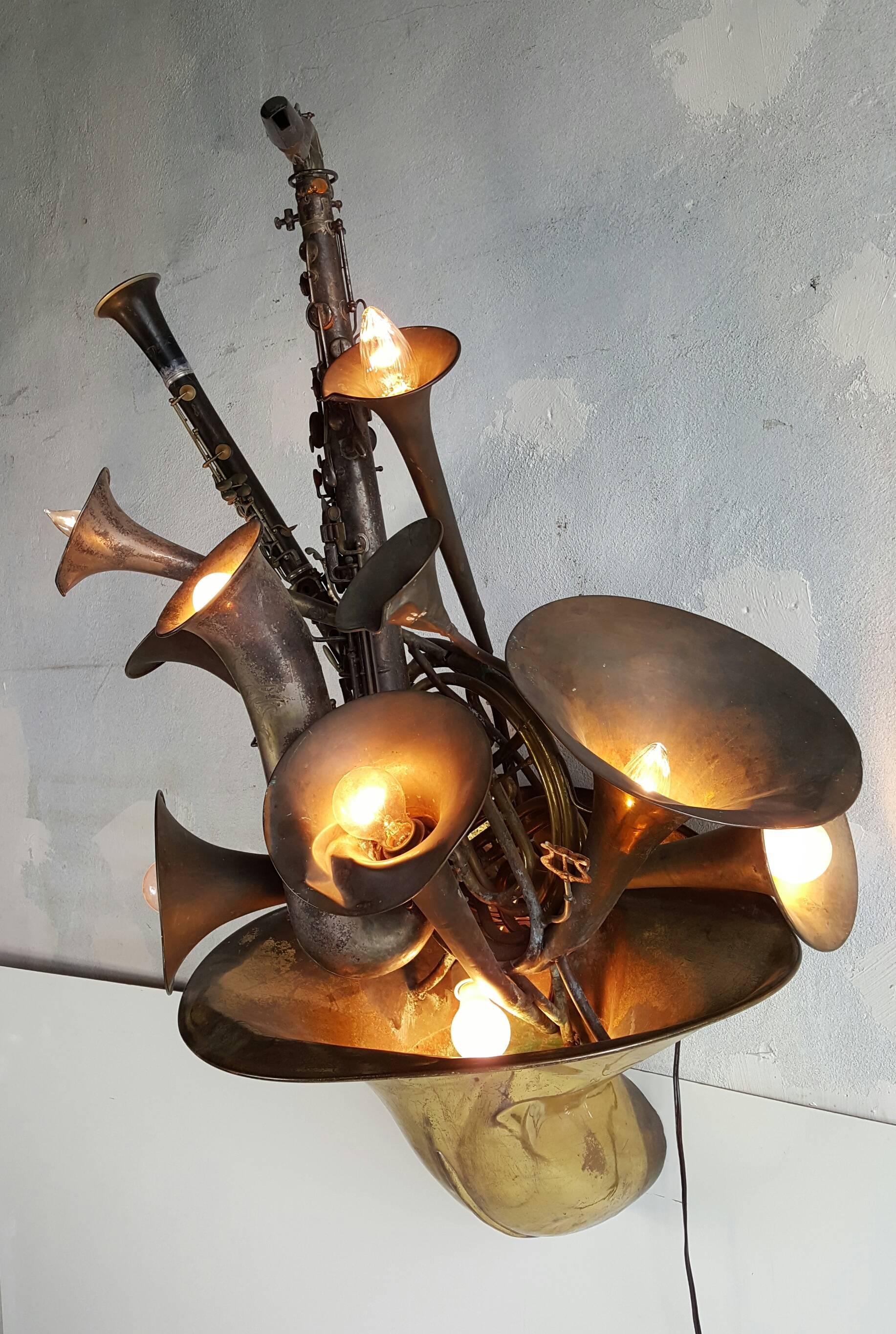 Unusual handmade multi-light wall sconce constructed of various wind instruments including saxophone, French horn, clarinet, trombone, trumpet and baritone bells. All instruments in antique original condition, signs of wear and tear, adds to the