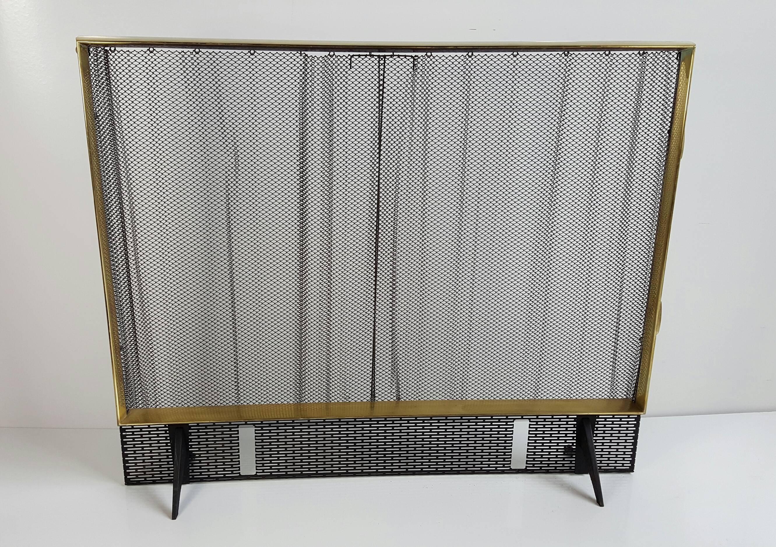 Elegant black iron and polished brass set designed by Donald Deskey for Bennett, includes fire screen, andirons, fire tools and stand. Andirons are signed 