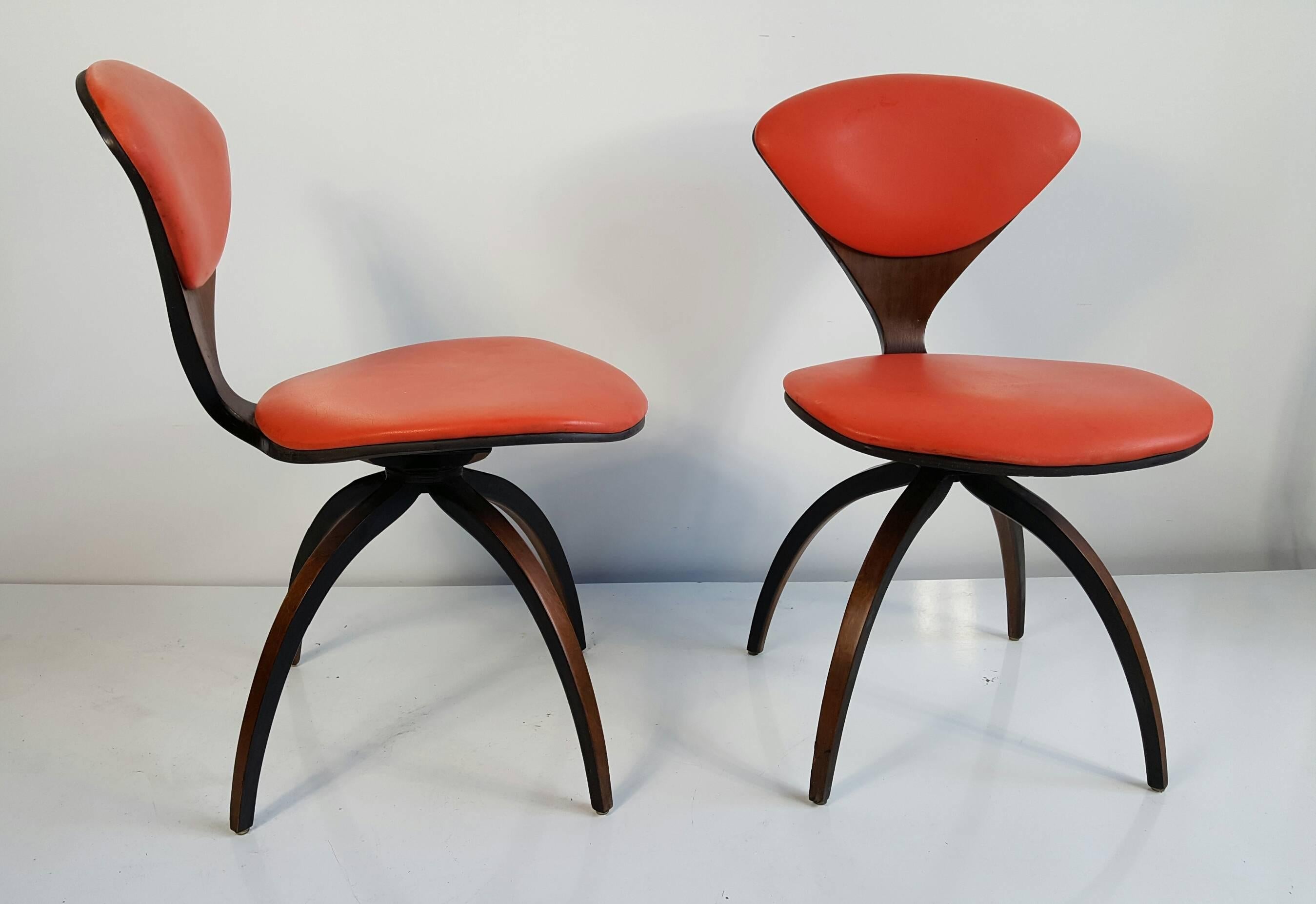Pair of Norman Cherner swivel chairs for Plycraft, American, circa 1959. Natural walnut frames, original orange naugahyde seat and back upholstery, excellent original condition.