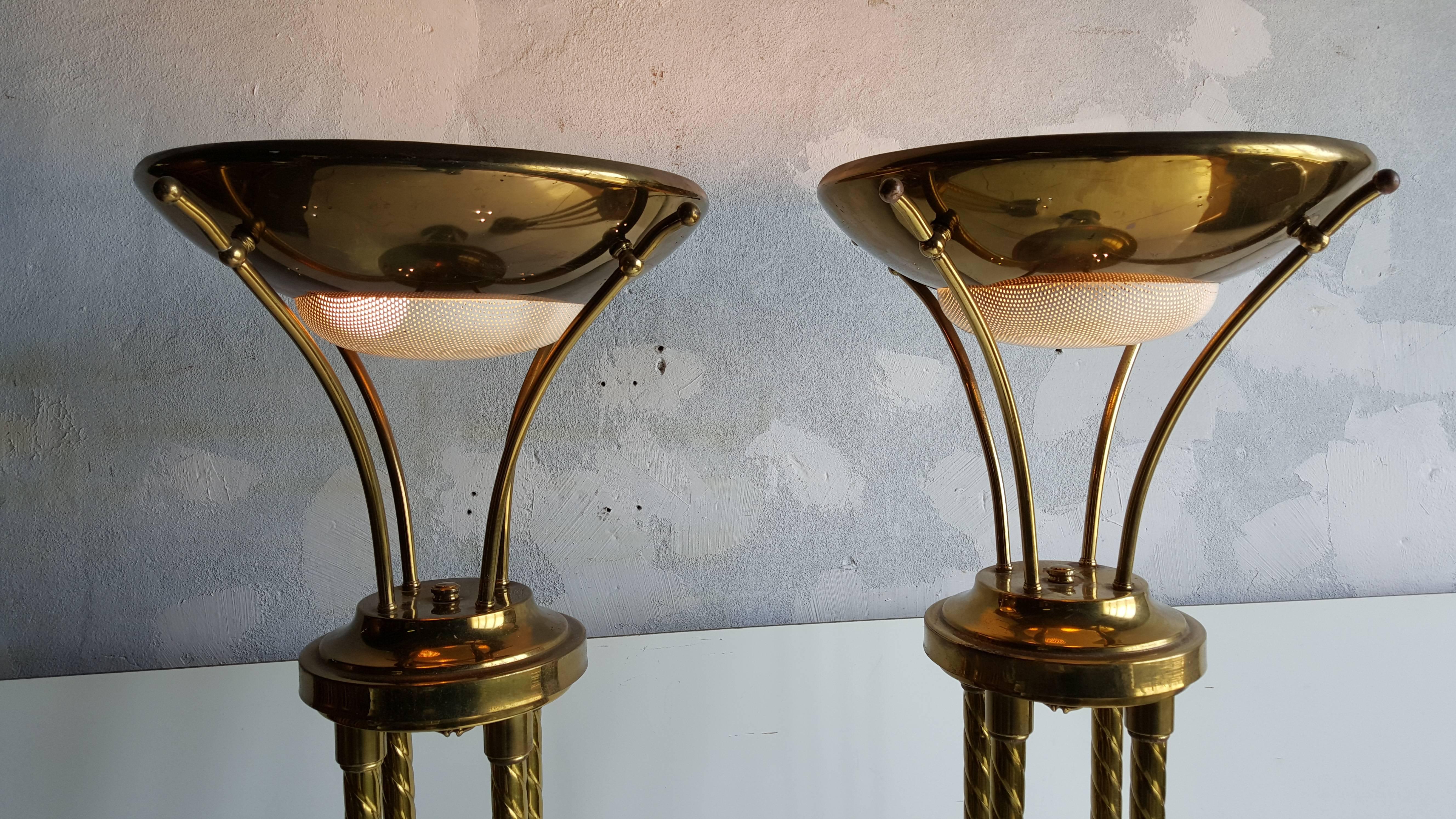 Pair of modernist brass and metal torcheres. Retains original white perforated defusser, three-way light capability, unusual brass ball and flower petal design centers four twisted brass standards, minor rust to bottoms.