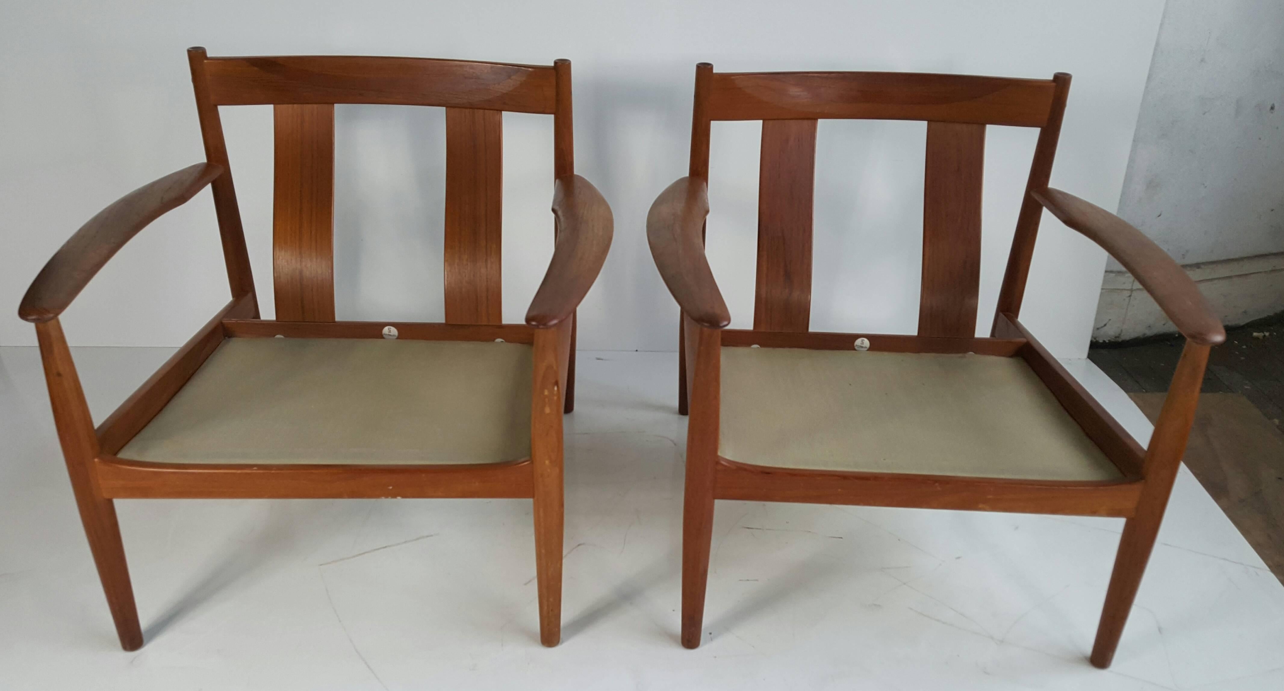 Classic Danish modern pair of lounge chairs, model 118 easy chairs by Grete Jalk for France & Son, Denmark, solid teak wood frames, retains original spring coil seat and back cushions as well as France and Sons Metal badges.