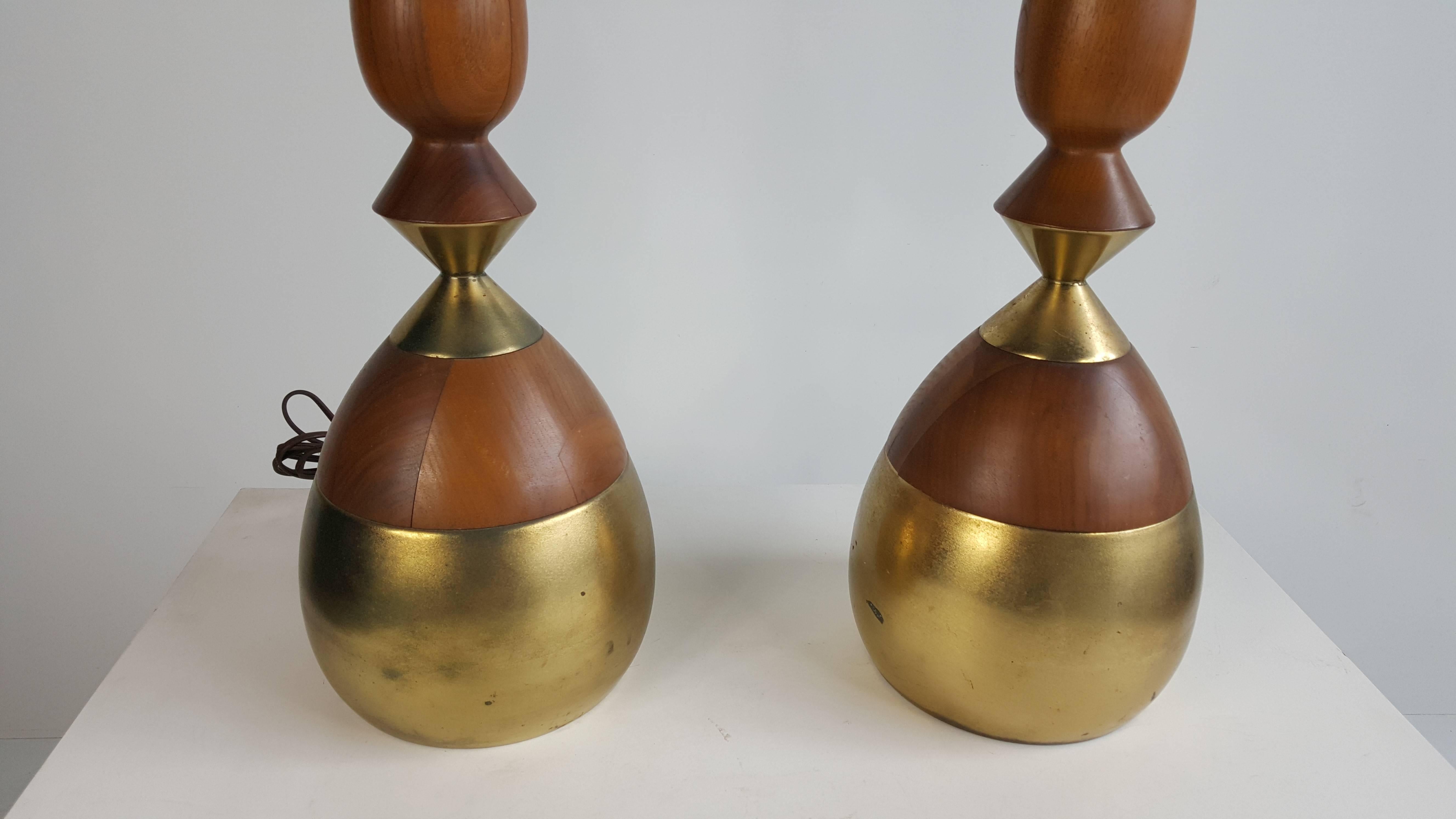 Classic pair of Mid-Century Modern table lamps designed by Tony Paul. Turned walnut and brass, Fit seamlessly into any environment, minor separation to wood, hardly noticeable.