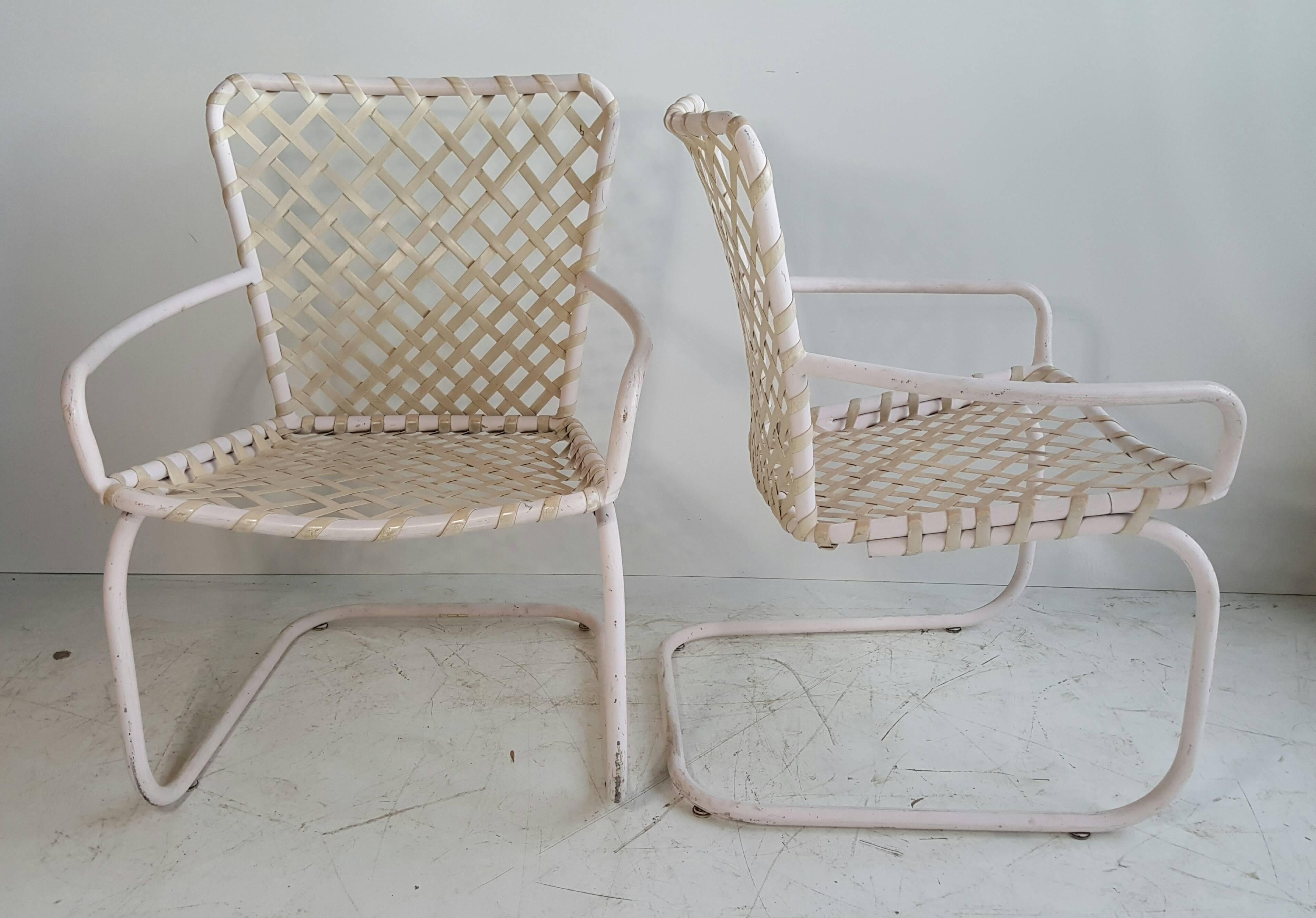 Pair of Classic Mid-Century Modern Russell Woodard patio spring lounge chairs. Nice original condition, weaved plastic and powder coated tubular metal frames, extremely comfortable, slight bounce.