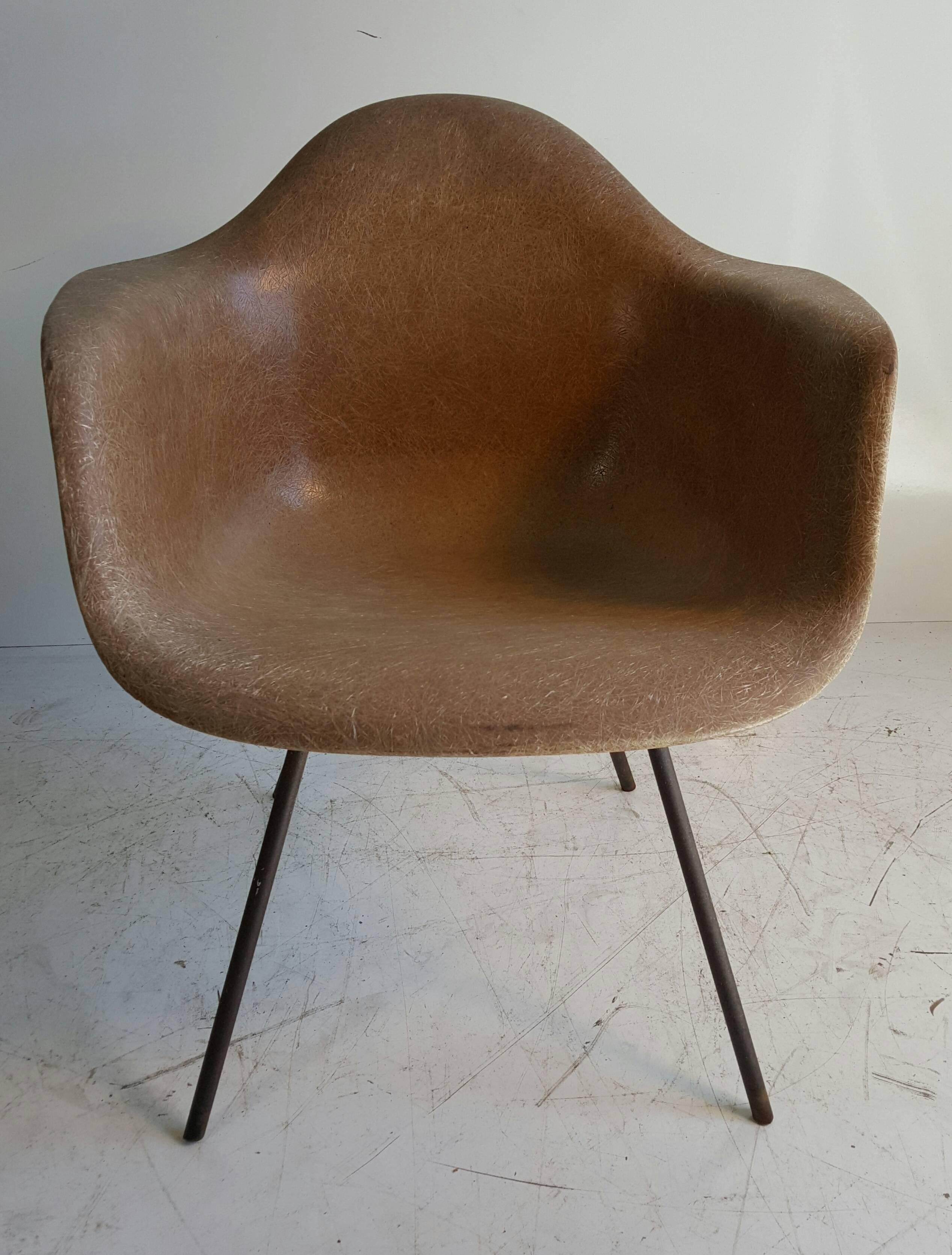 Classic Mid-Century fiberglass arm shell chair designed by Charles and Ray Eames, 2nd year production featuring early exposed fibers, heavy iron x base, large rubber shock monts, unusual color.