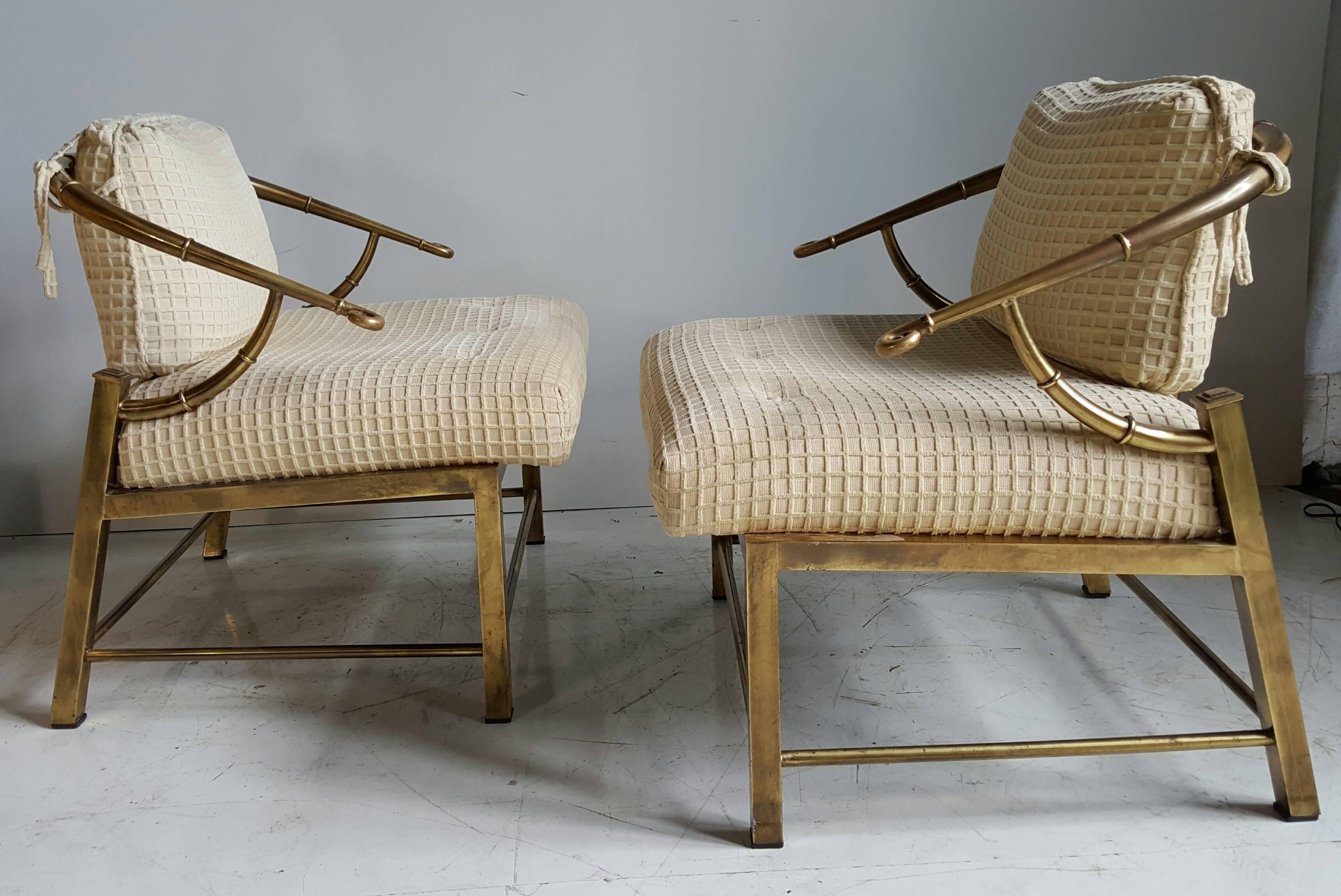 Pair of Asian inspired, faux bamboo brass lounge chairs by Mastercraft, circa 1970s. Retain original fabric, nice useable condition. Brass has a warm original patina. Generous seat proportions. 1970s chinoiserie brass horseshoe burnished brass