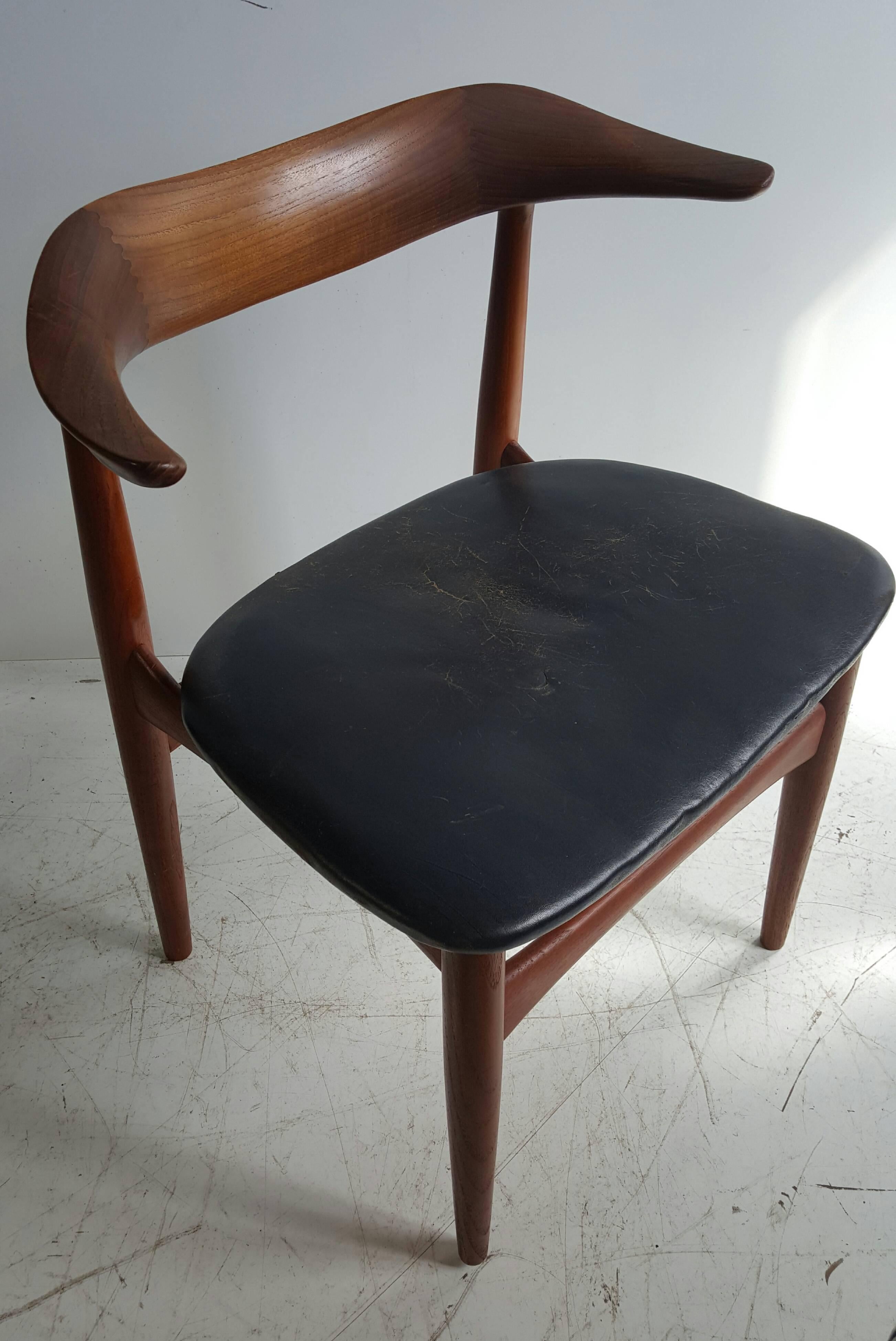 Danish modern walnut and leather armchair by Povl Dinesen. Classic design and superior quality featuring beautiful turned and wood and joinery, would be a handsome desk or occasional chair. Retains original black leather seat cushion (small split to