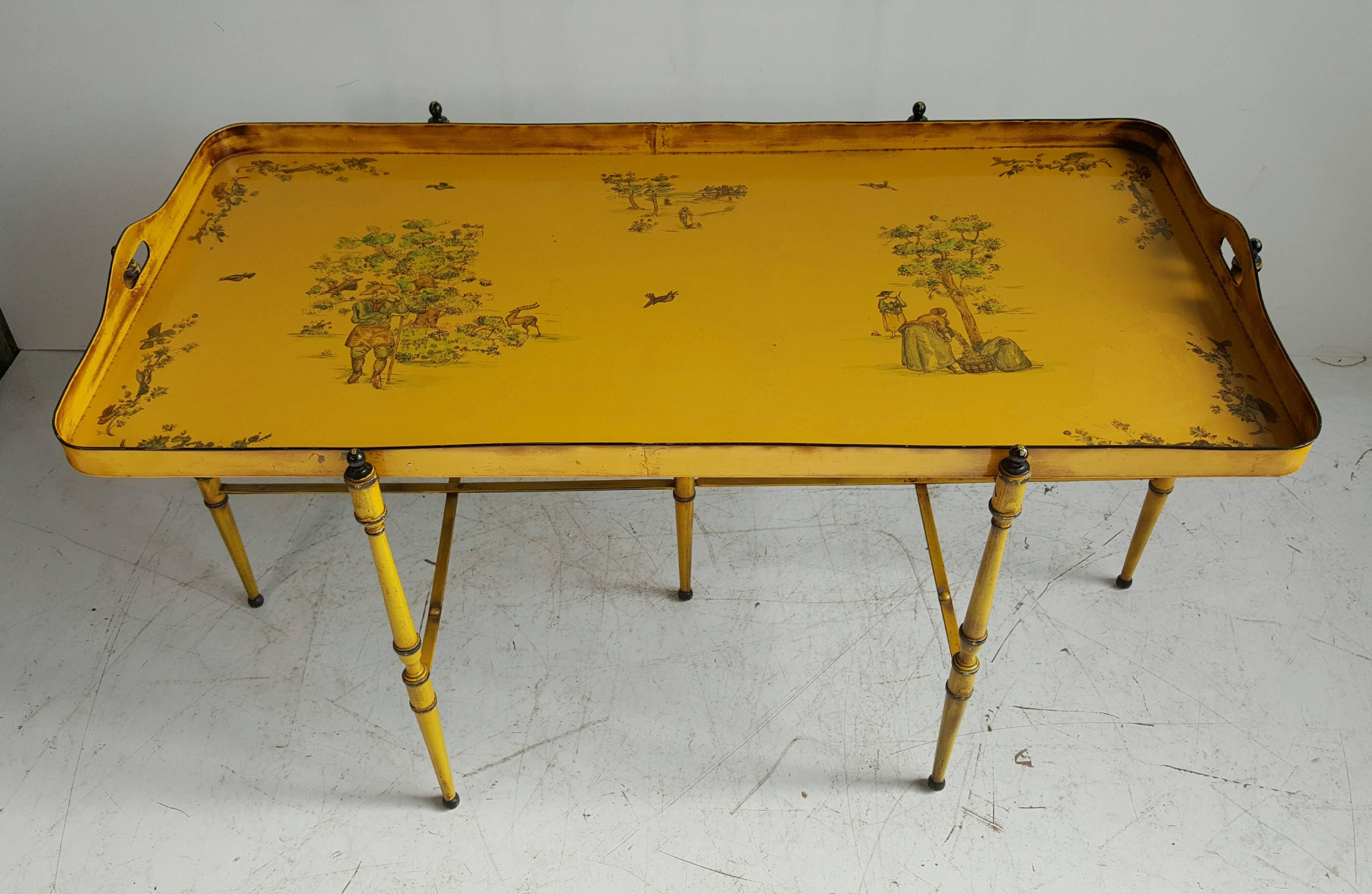 Late 20th century Italian tole tray table of painted metal in yellow, featuring wonderful hand-painted scenes Asian inspired, rich vibrant colors, all resting upon a folding metal stand of yellow with black accents, large removable tray.