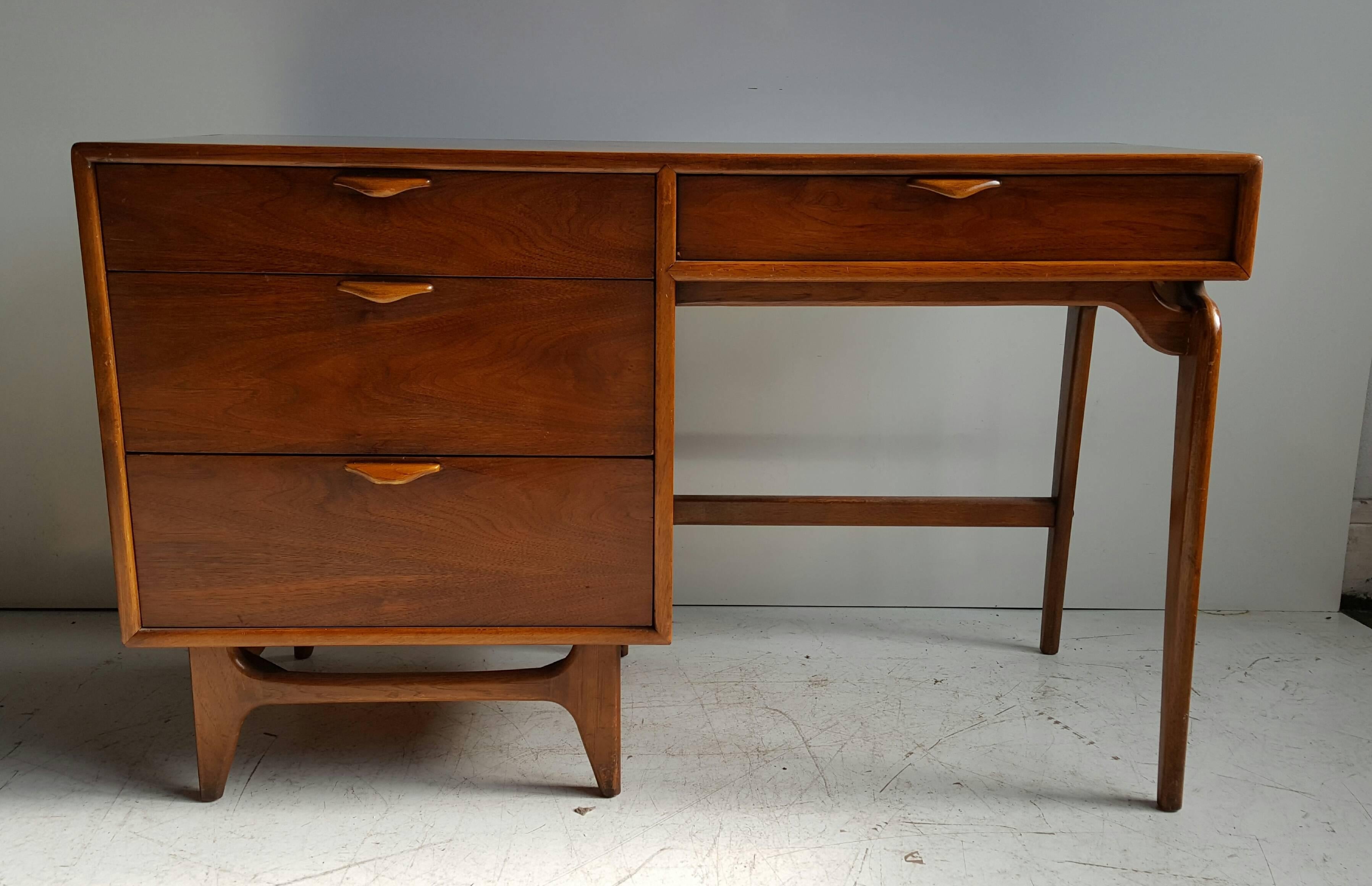 Modernist walnut desk, Andre Bus for Lane, Classic Mid-Century Modern design. Great quality as expected with Lane fine furniture, wonderful sculptural hand pulls, desk features four generious size drawers, beautiful warm walnut, retains original