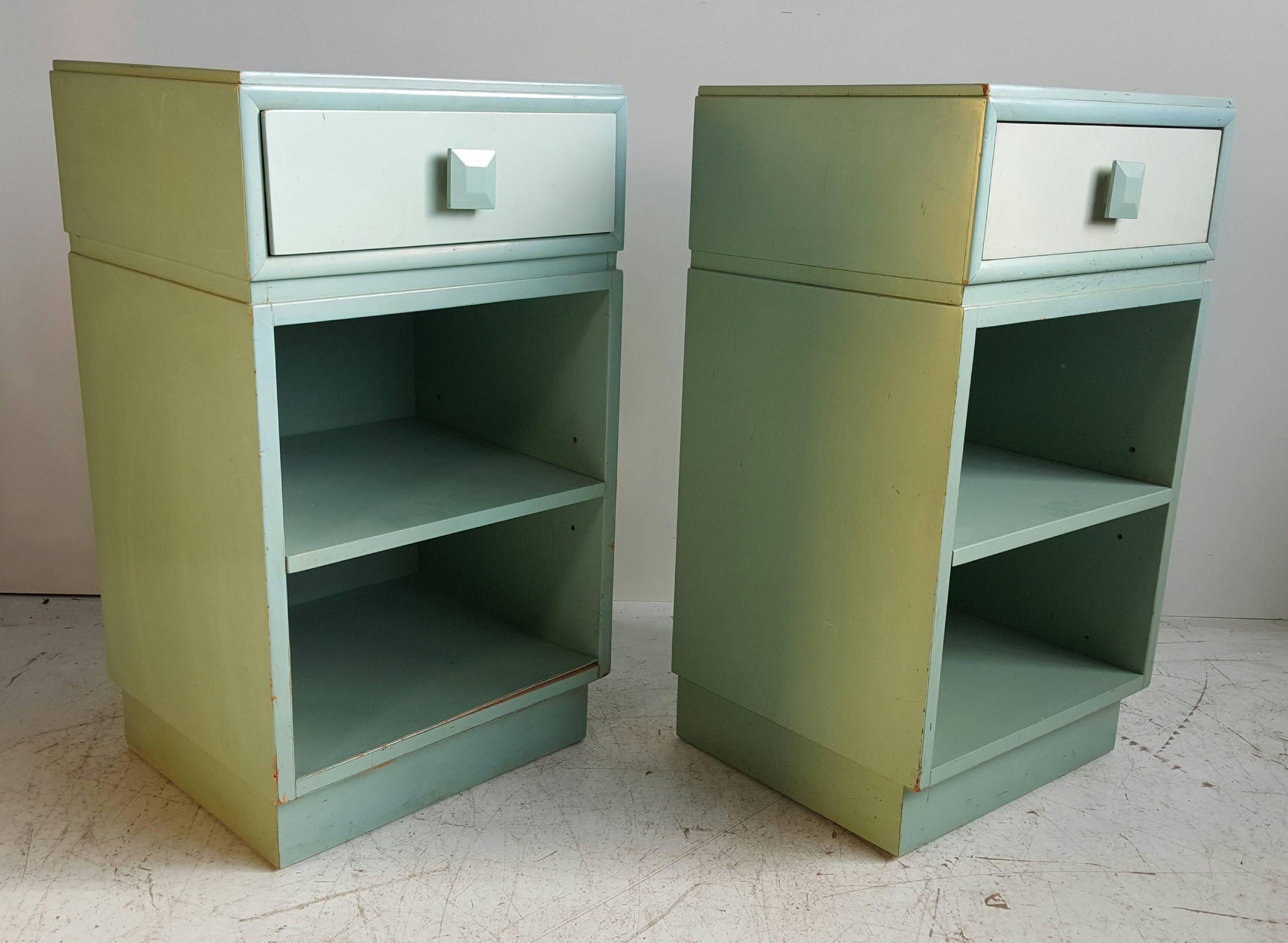 Great pair of 1940s side tables with drawer. The two-tone finish in original factory paint, visible wear. Shelf is adjustable. Drawer marked with Kittinger foil label.