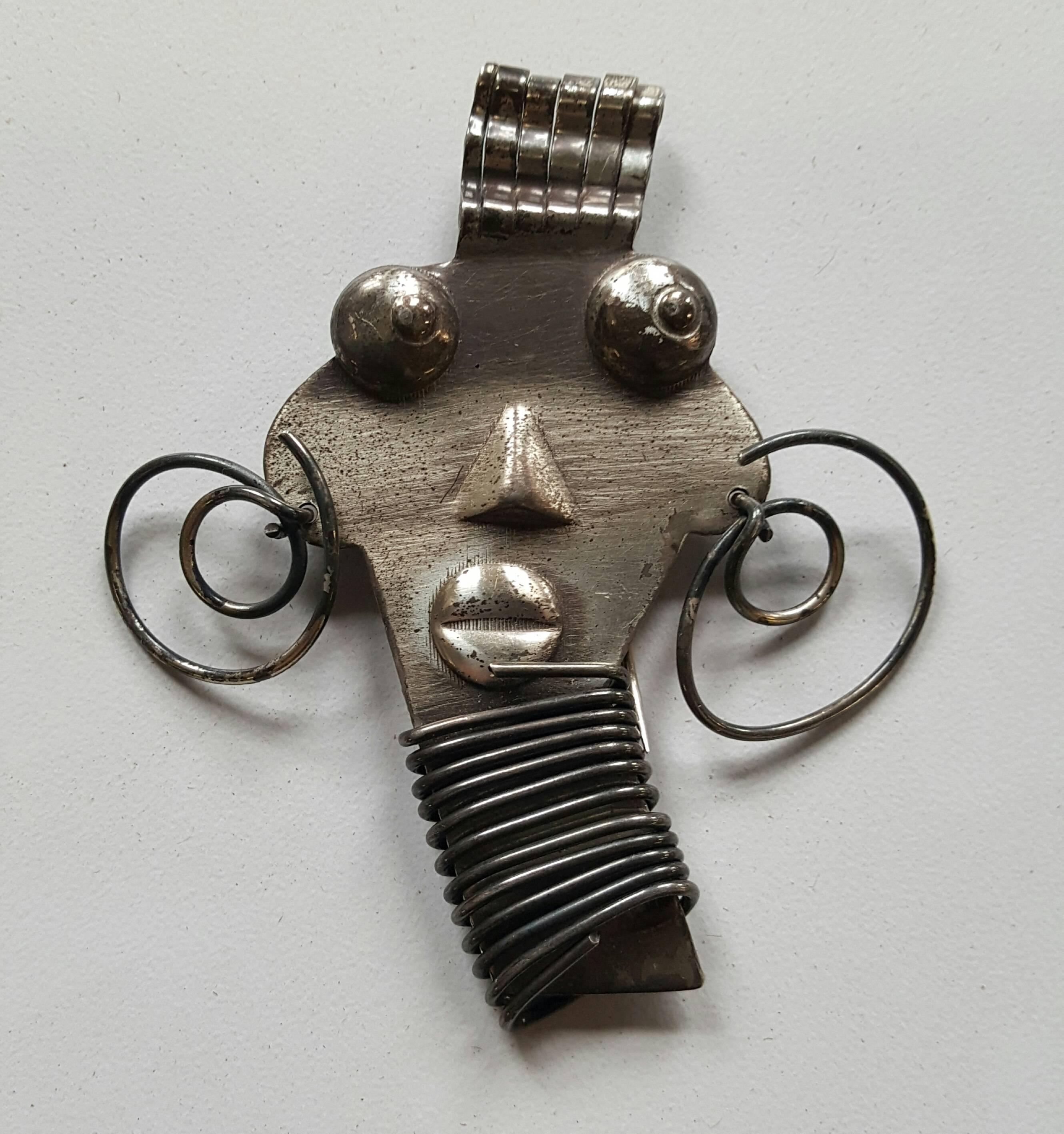 1950s ubangi woman pin is among the most striking of artist Rebajes pieces. Seldom seen sterling silver version, as most Rebajes pieces are in copper. It is jigsaw cut with wrapped wire throat, wire earrings curled hair and characteristic oxidized