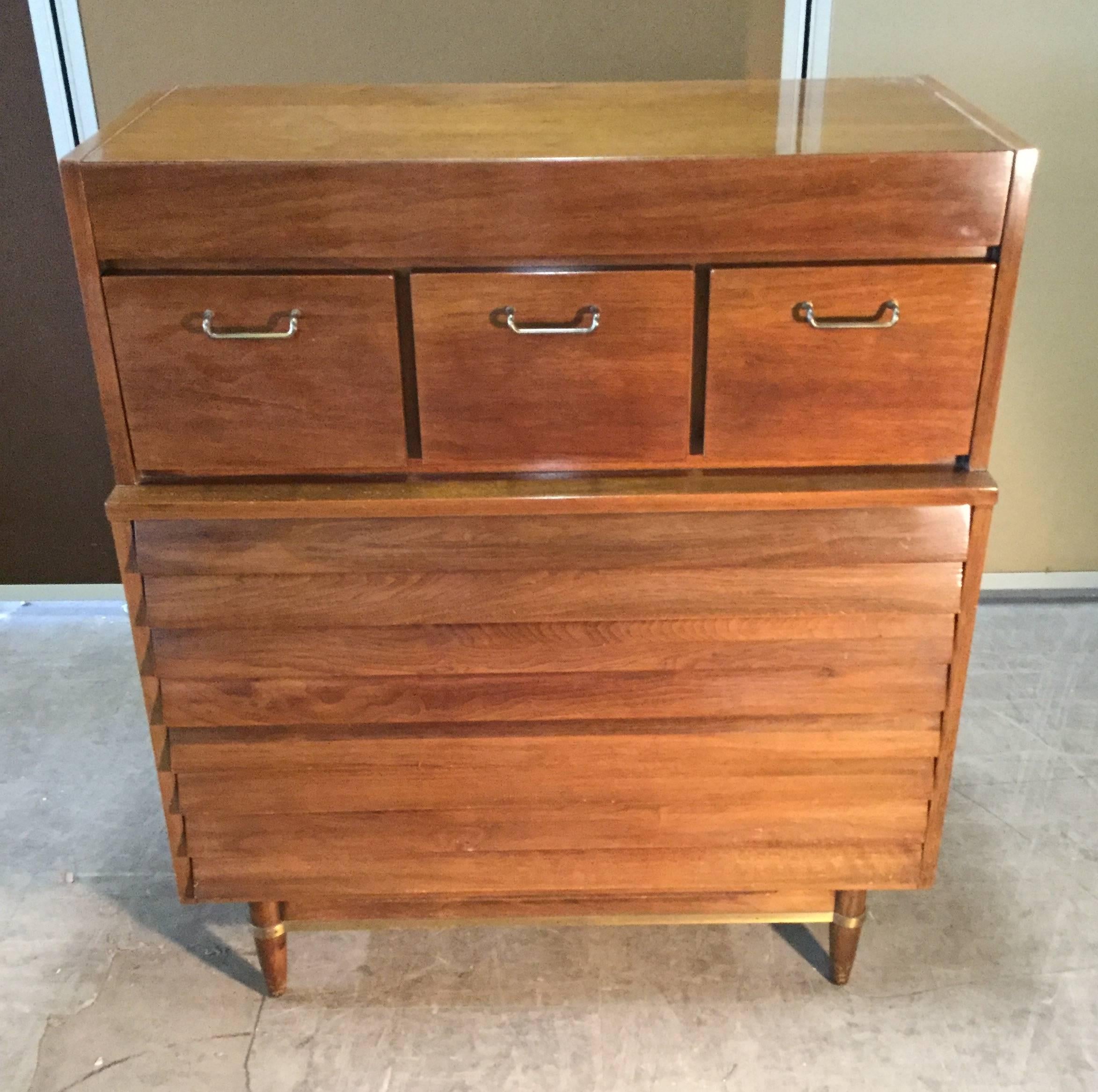 A Classic tall chest by Merton Gershun for his Dania collection manufactured by American of Martinsville. Features three drawers over three generous drawers with louver fronts. Brass detail.