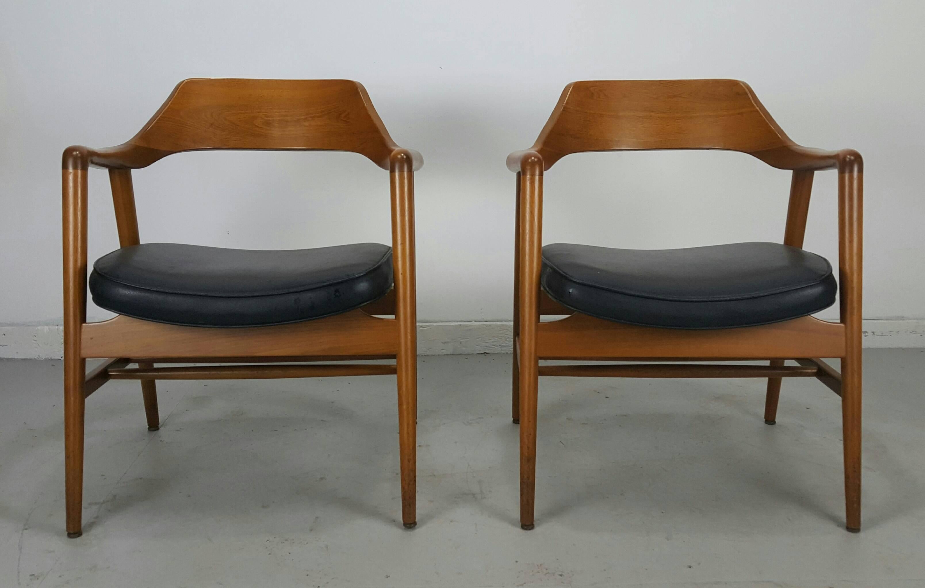 Set of eight sculptural solid walnut armchairs by Gunlock Classic modernist design. Exceptional quality and construction. Amazing original condition. Retains original black naugahyde seats. Measure 29.5" H x 24" W x 22" D. Arm height