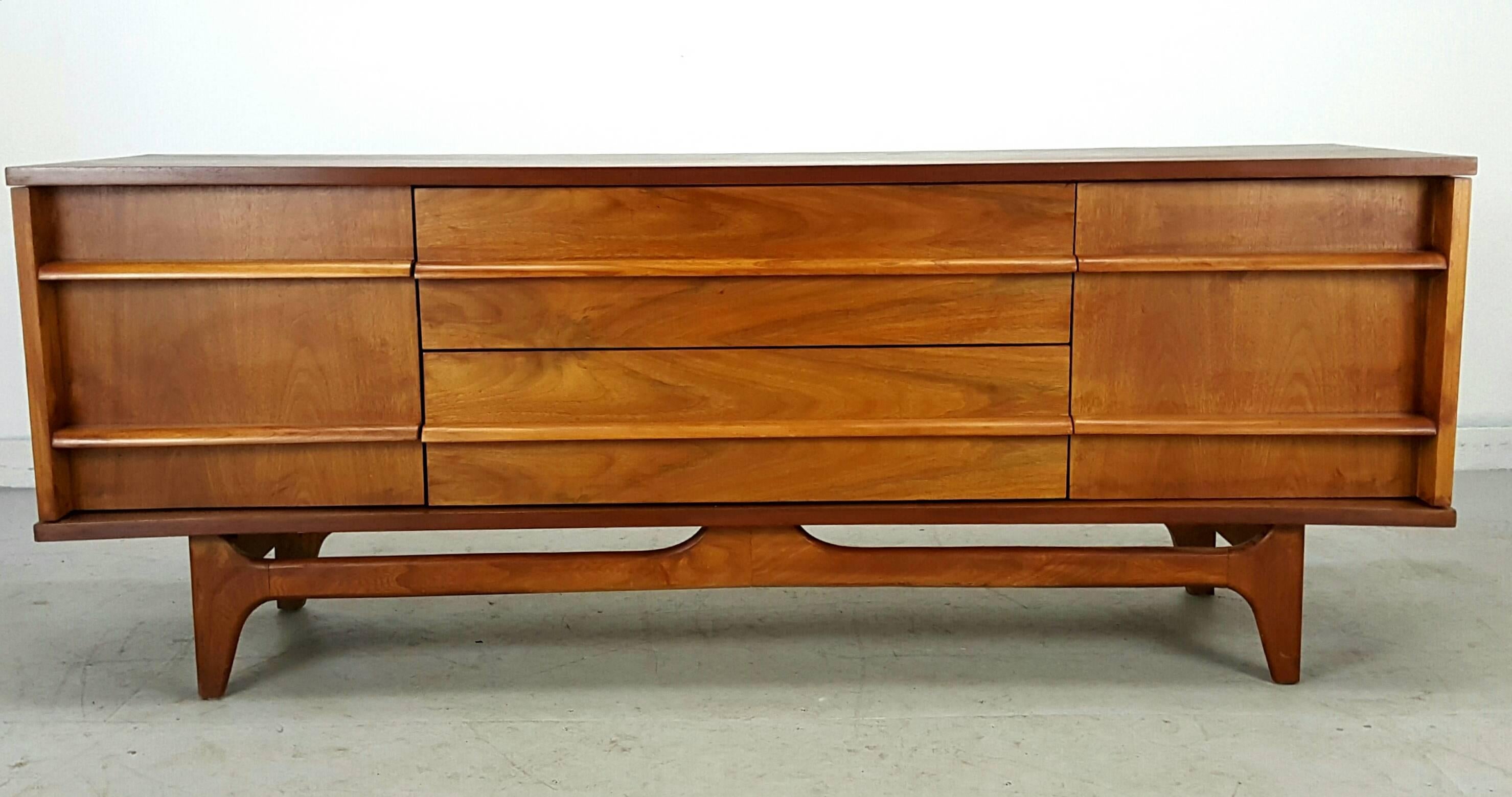 Modernist server featuring two doors and three drawers. Handsome bow front with angled drawer pulls that run the length of piece. Wonderful wood graining, measures 64.0