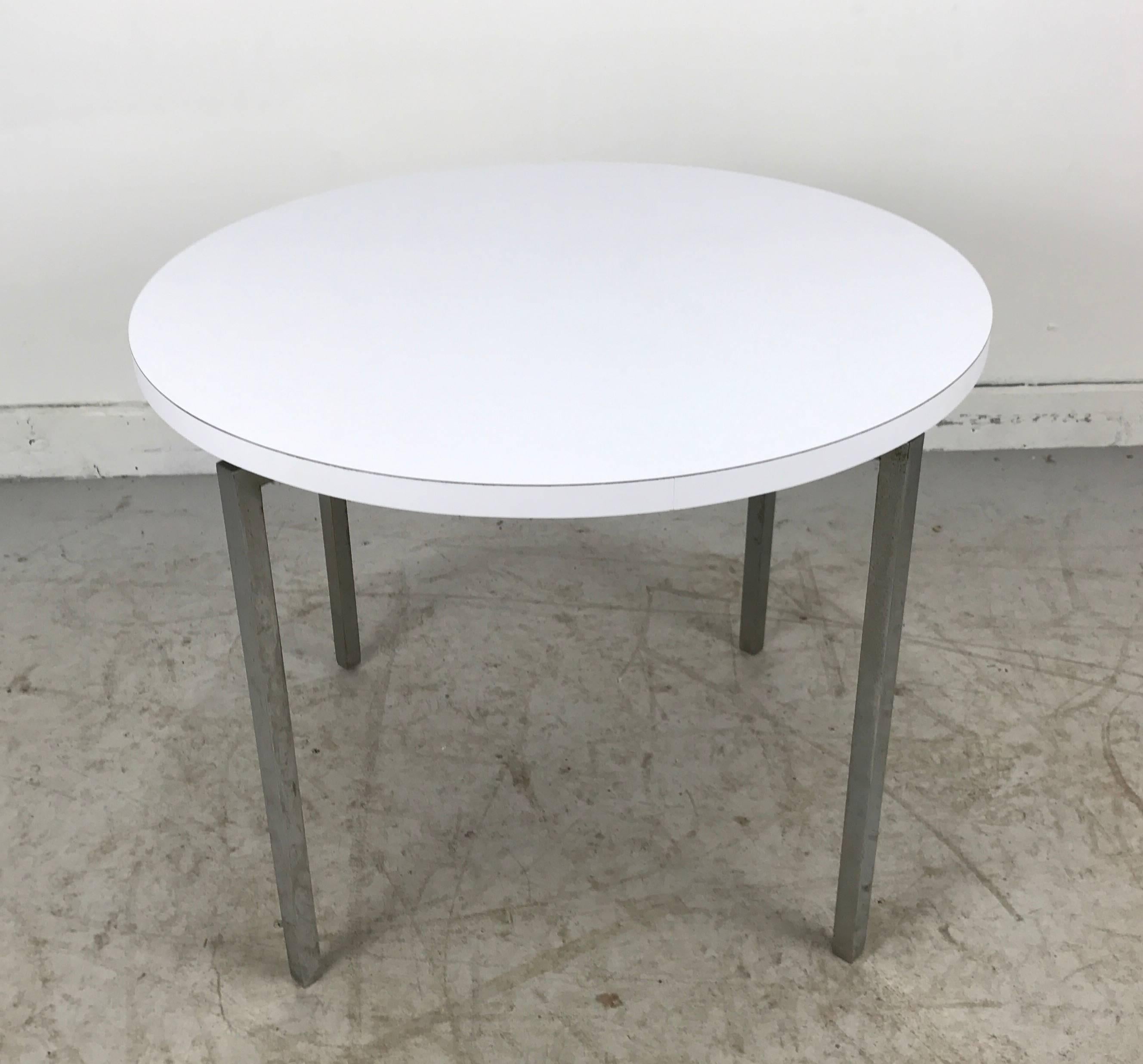 Classico design architettonico modernista con piano rotondo in laminato bianco e solida base a 
