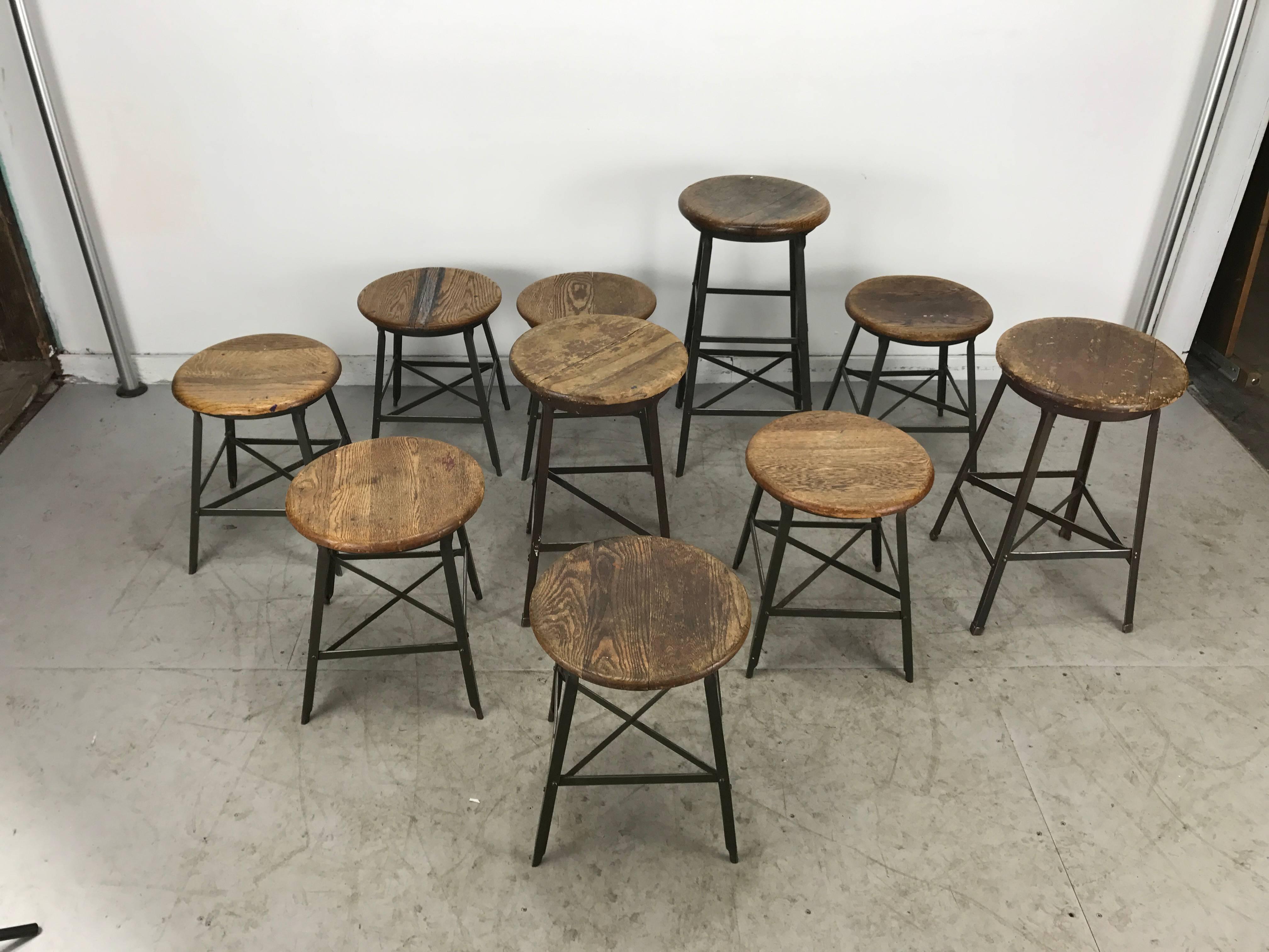 Nice matched set of antique industrial stools made in Chicago, circa 1920s. 8 stools (small) measuring 18" H ,1 stool(medium) measuring 23.5" H 1 stool (standard) 28" H  All retain original oak tops 14.5" in diameter. Also retain