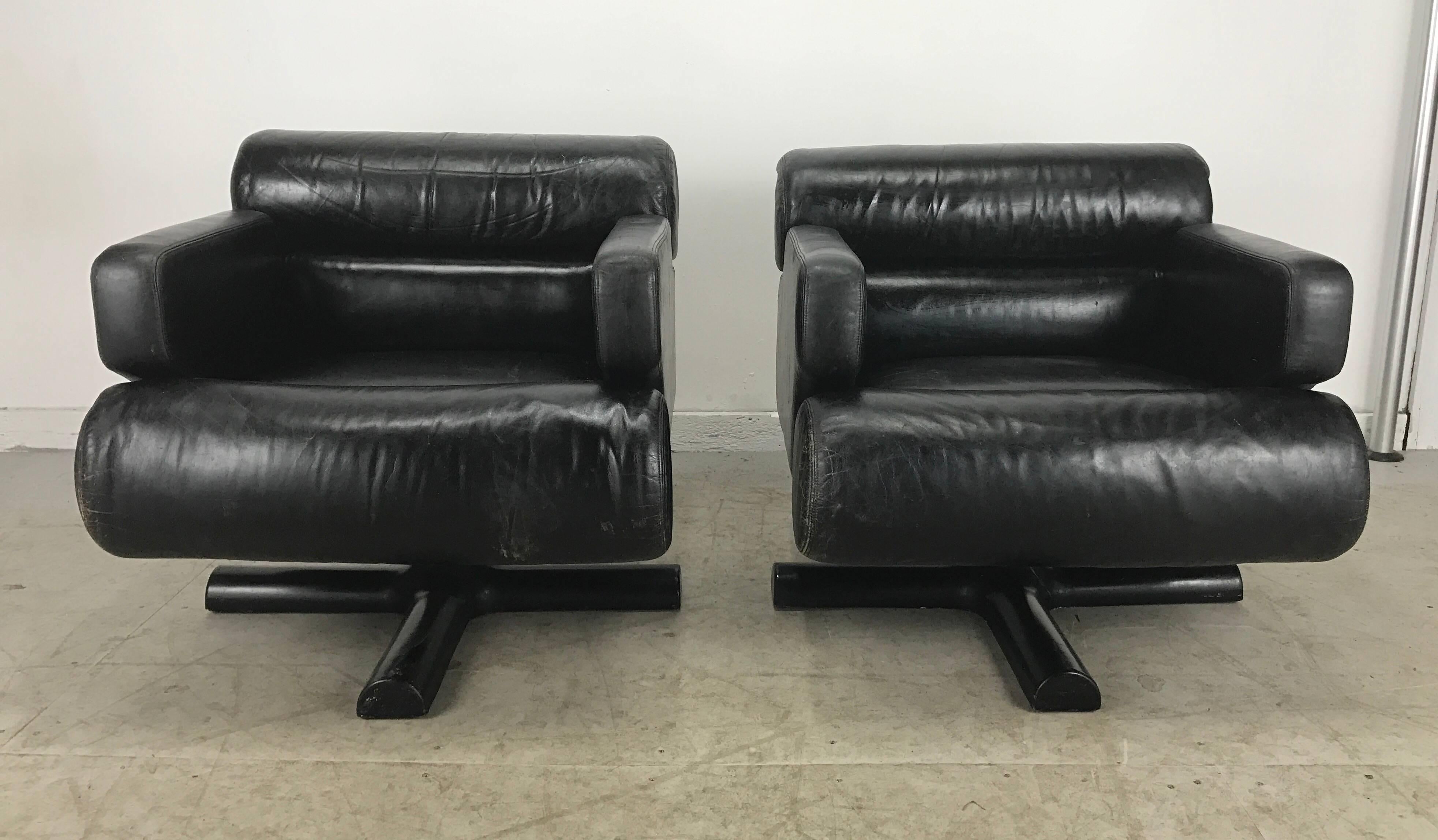 Stunning and sexy pair of black leather lounge chairs, Space age ..pop..reminiscent of classic Italian designs by the likes of by Joe Colombo,etc. Nice original condition, adjustable tilt swivel mechenism. Minor ware to leather, original fiberglass