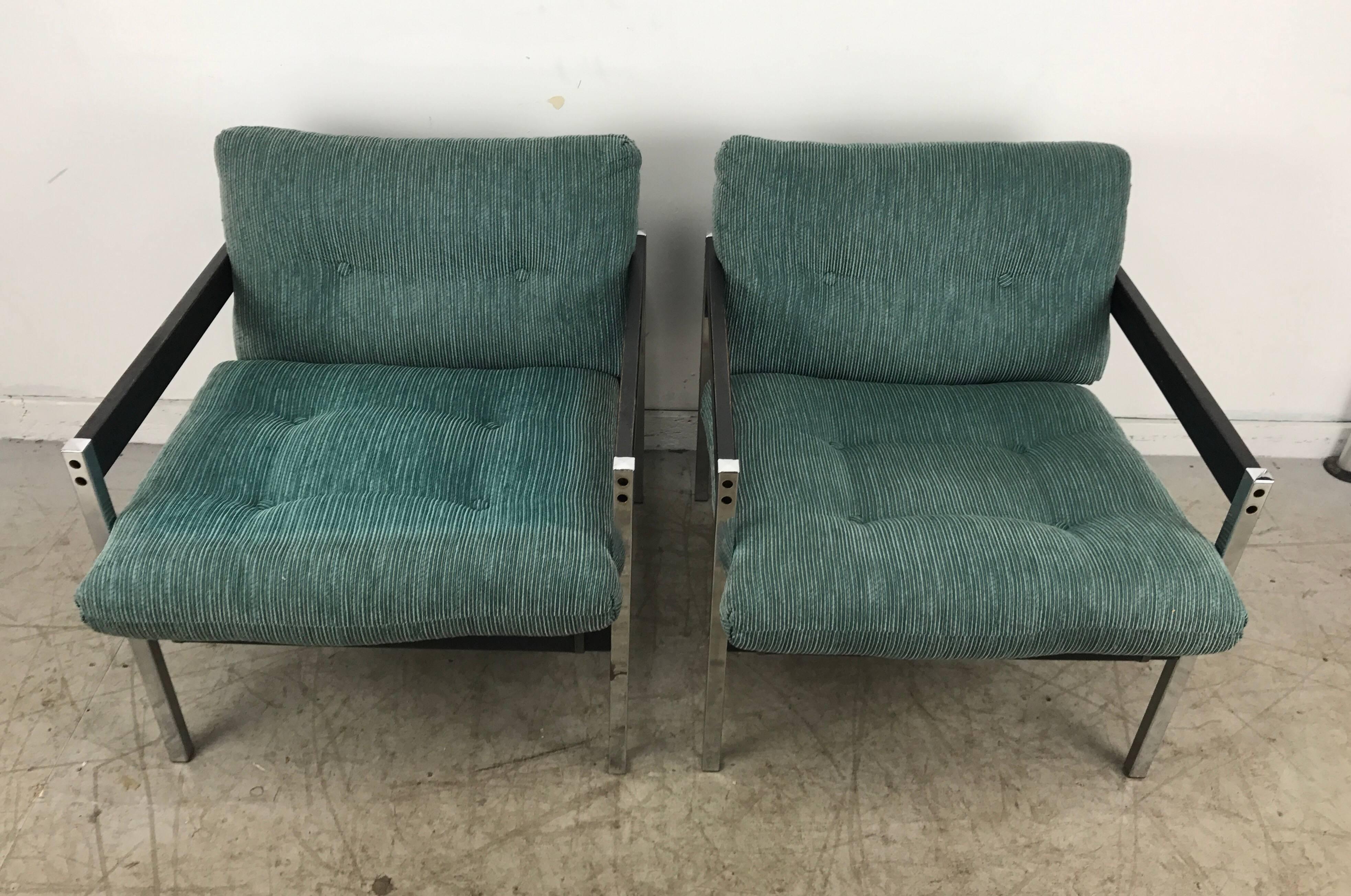 Pair of modernist chrome and wood sling lounge chairs after Charles Pollock. Handsome, elegant. Classic 1970s sling lounge. Extremely comfortable, retains original fabric.
