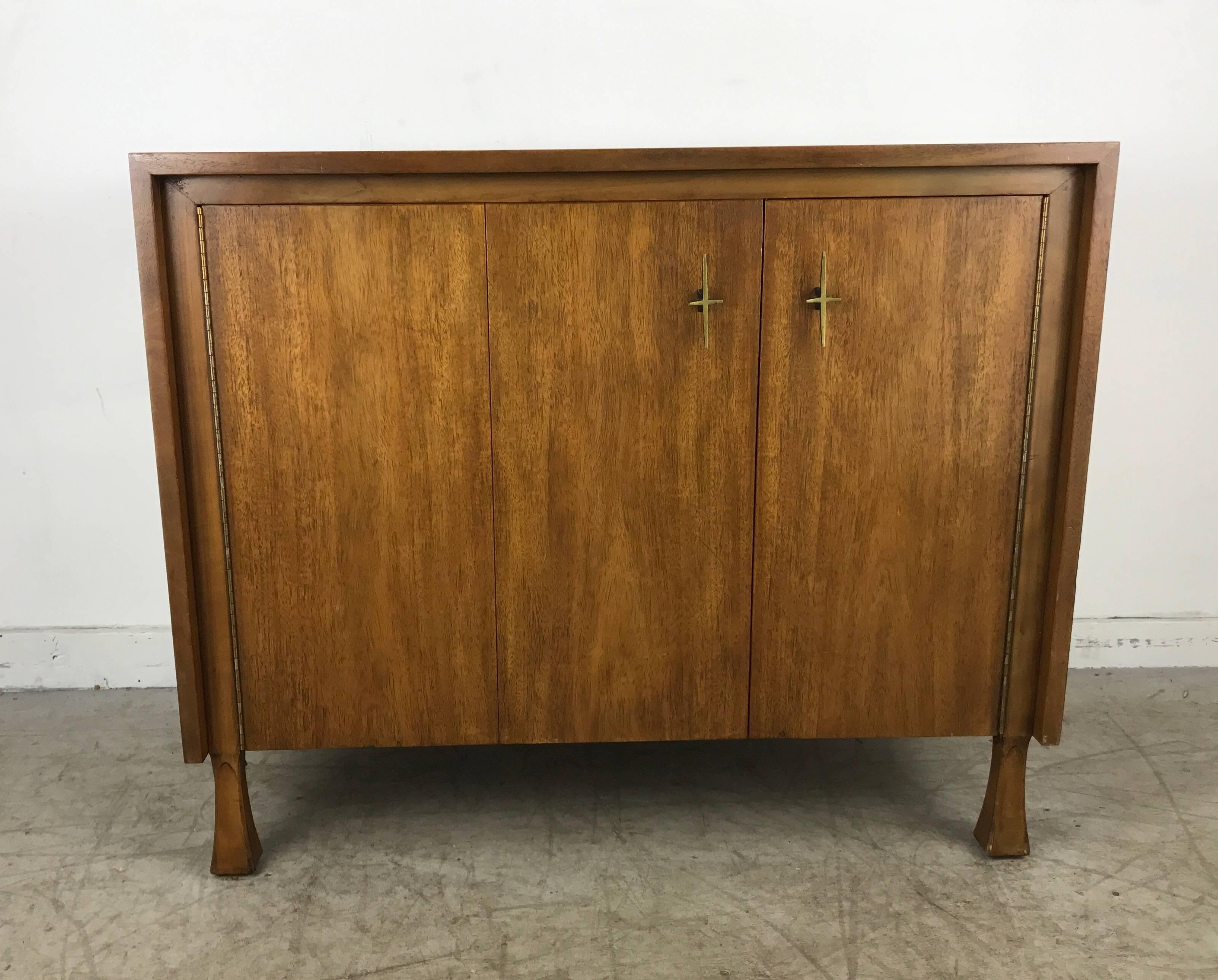 Stylized ribbon mahogany cabinet or dresser by John Widdicomb, superior quality, brass star pulls featuring left bi-fold door, three generous drawers, Classic modernist design, hand delivery available to New York City.