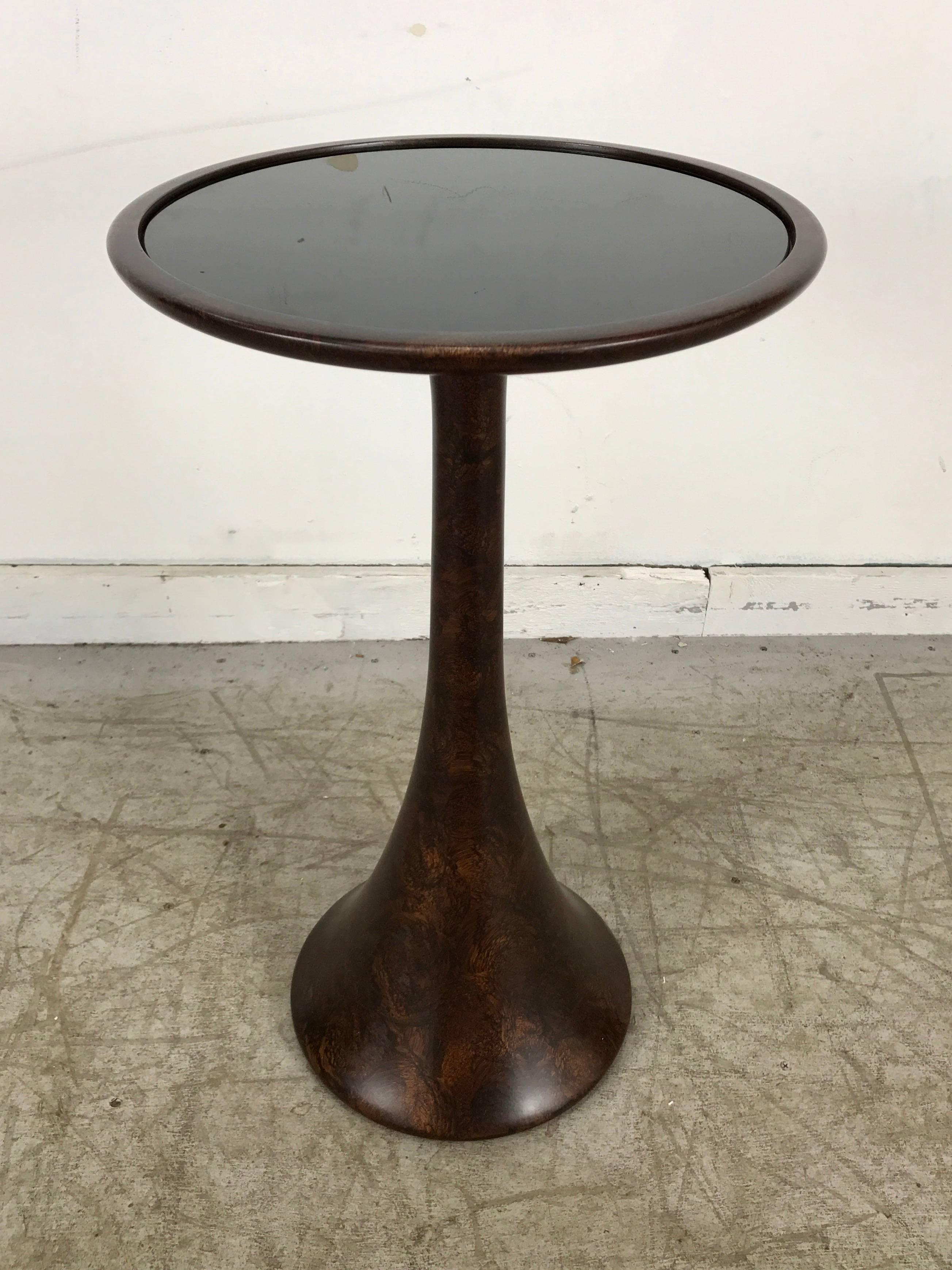Contemporary modernist trumpet base resin and glass table/pedestal. Stunning modeled faux walnut finish, Black glass insert top. Classic modernist form.