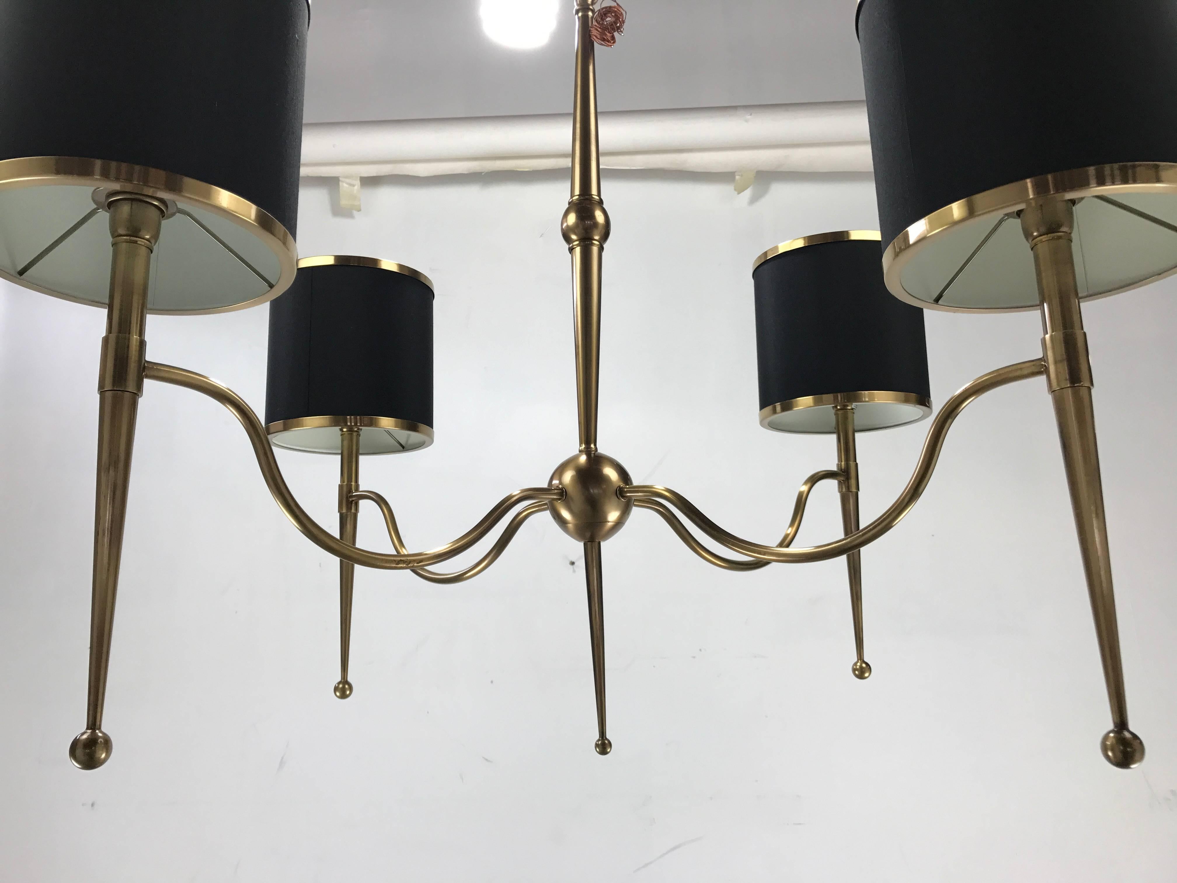 Regency modern four-arm chandelier. Antique bronzed finish, Classic design featuring brass trimmed shades (8in x 8in) tapering brass ball finials reminiscent of high style design by Tommi Parzinger, Gio Ponti and other similar designers.