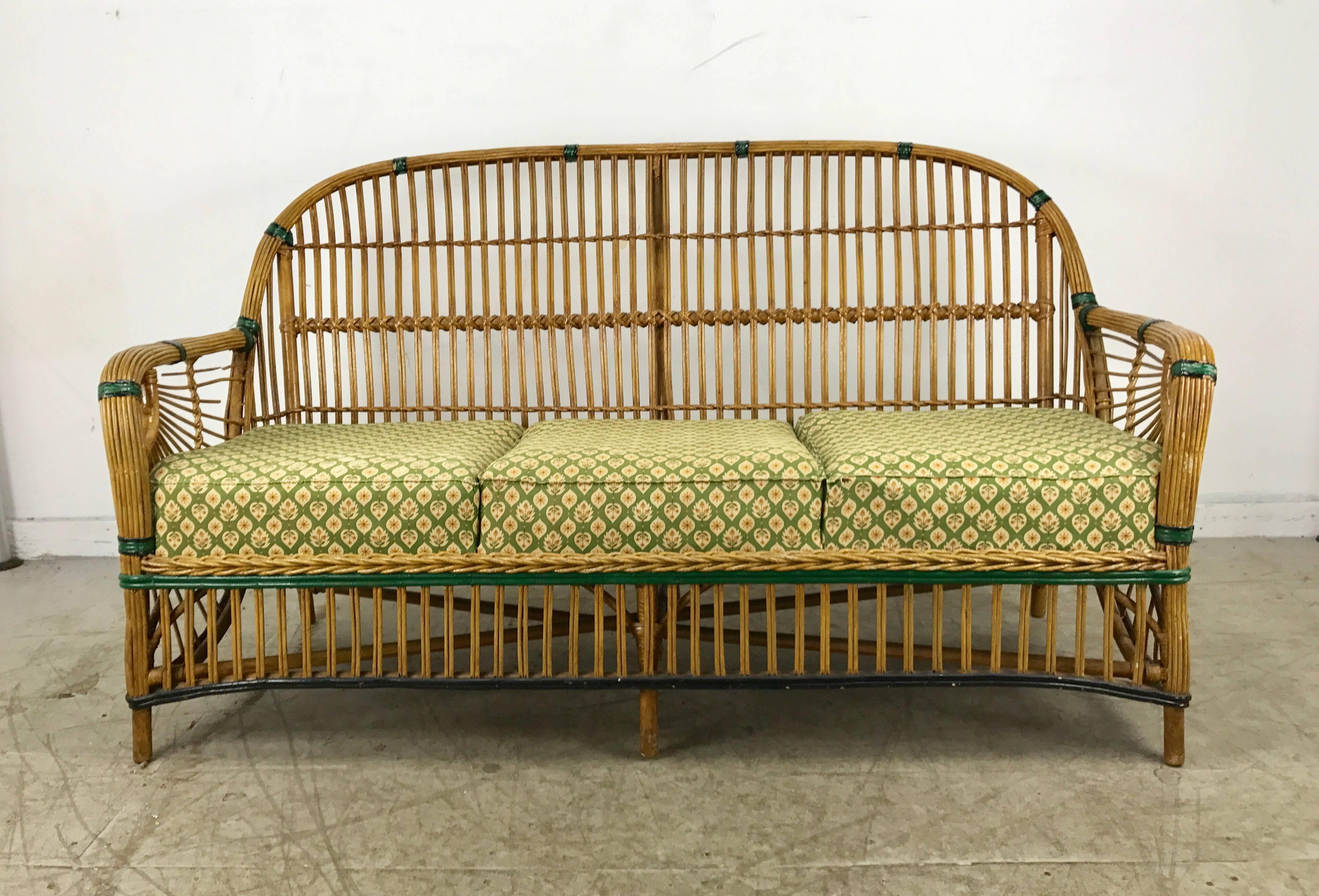 Stunning art deco split reed stick wicker settee. Features natural finish with beautiful green and black paint detailing. Also retains original spring cushions, stunning art deco 