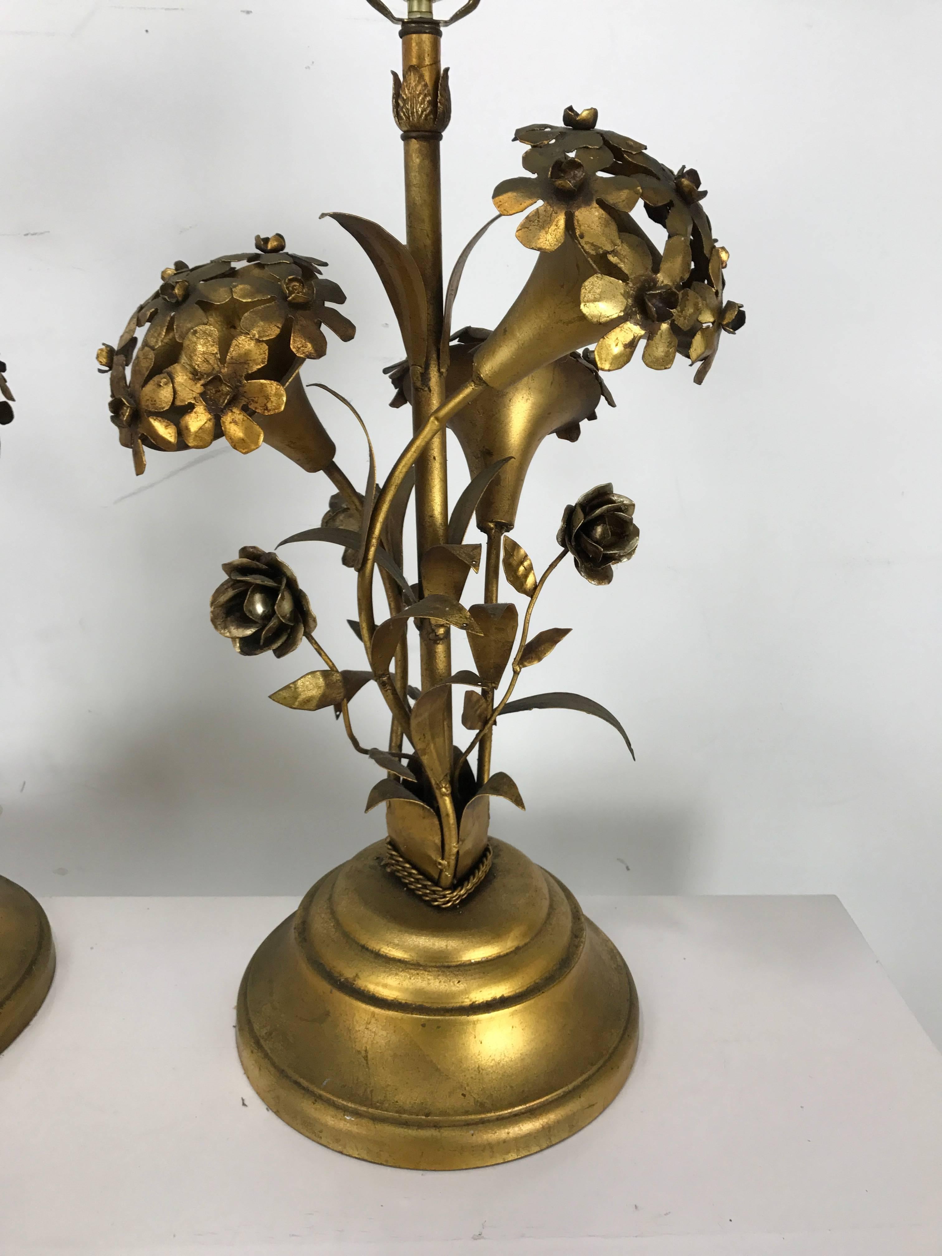 Pair of Regency modern gold gilt hydrangea themed table lamps. Wonderful gold patina, stylized hydrangea's retain original light bulb sockets which illuminate.