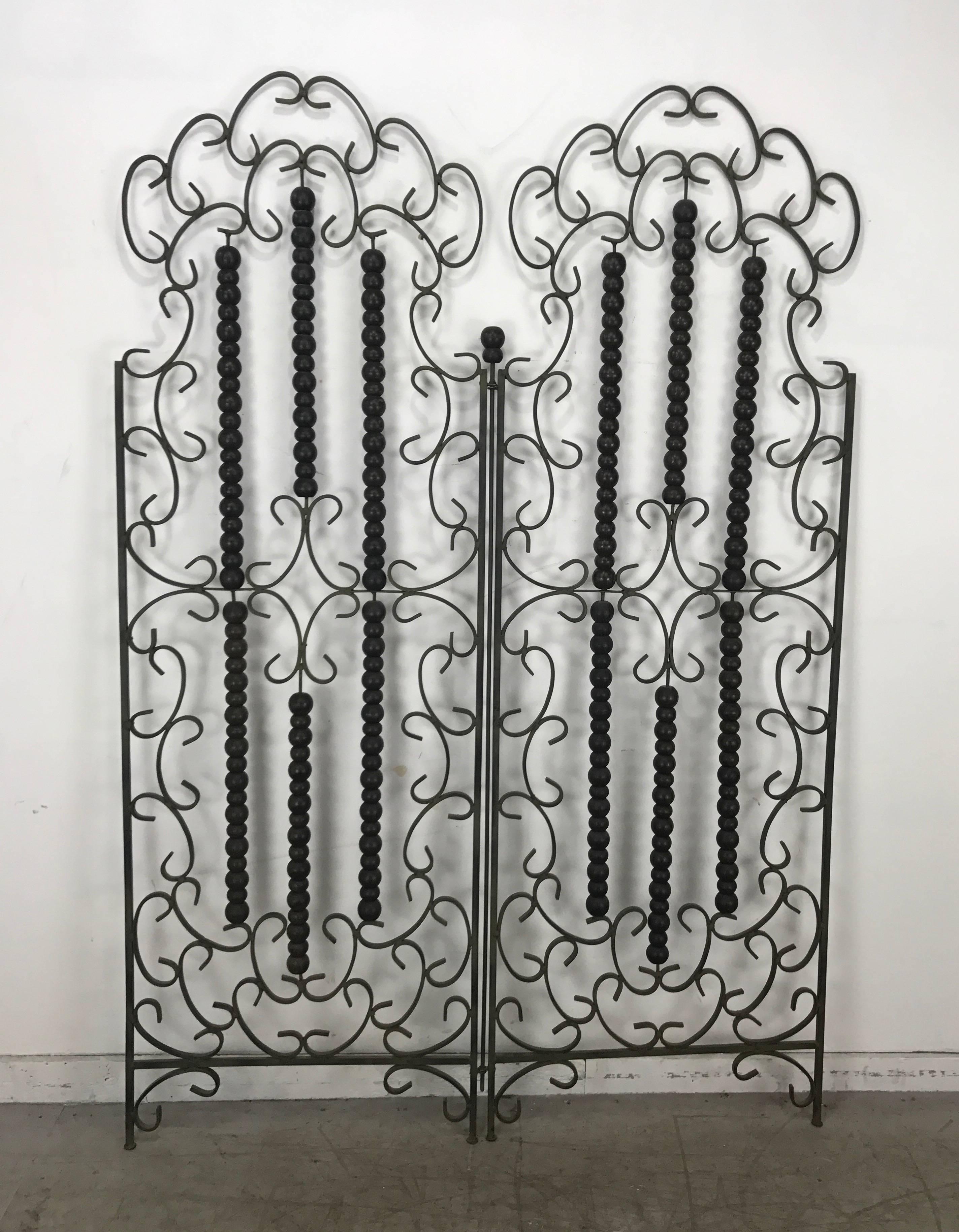 Wrought iron and wood (balls) Mediterranean Modern folding screen or divider. Wonderful bronzed verde green patina, bi-fold, hand delivery available to New York City or anywhere en route from Buffalo Ny.